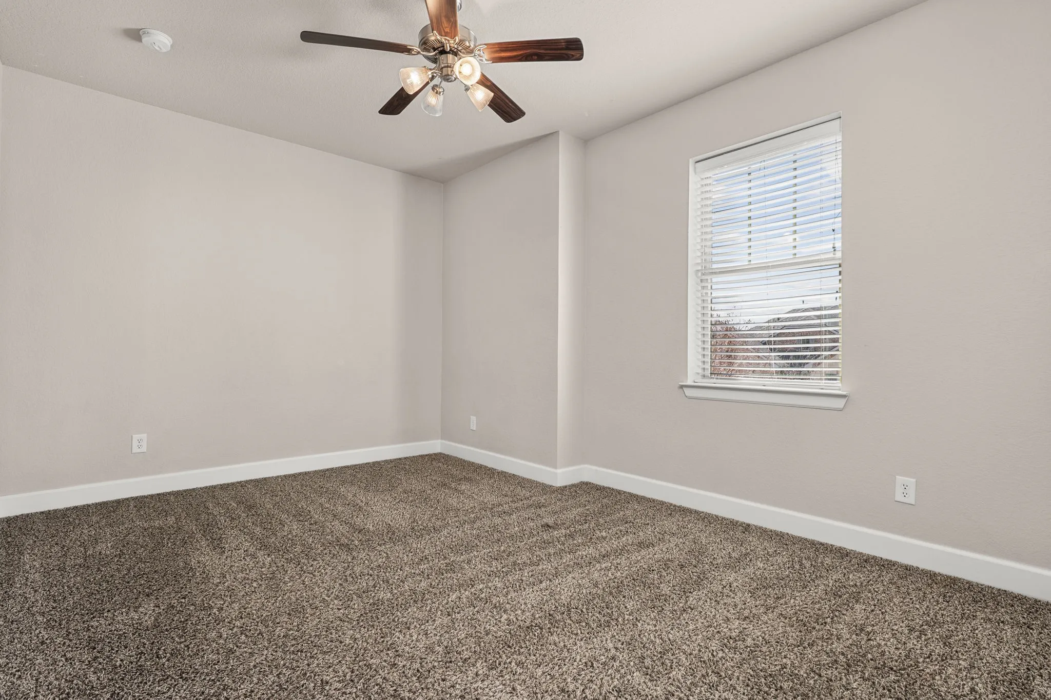 Unfurnished room with dark carpet and ceiling fan