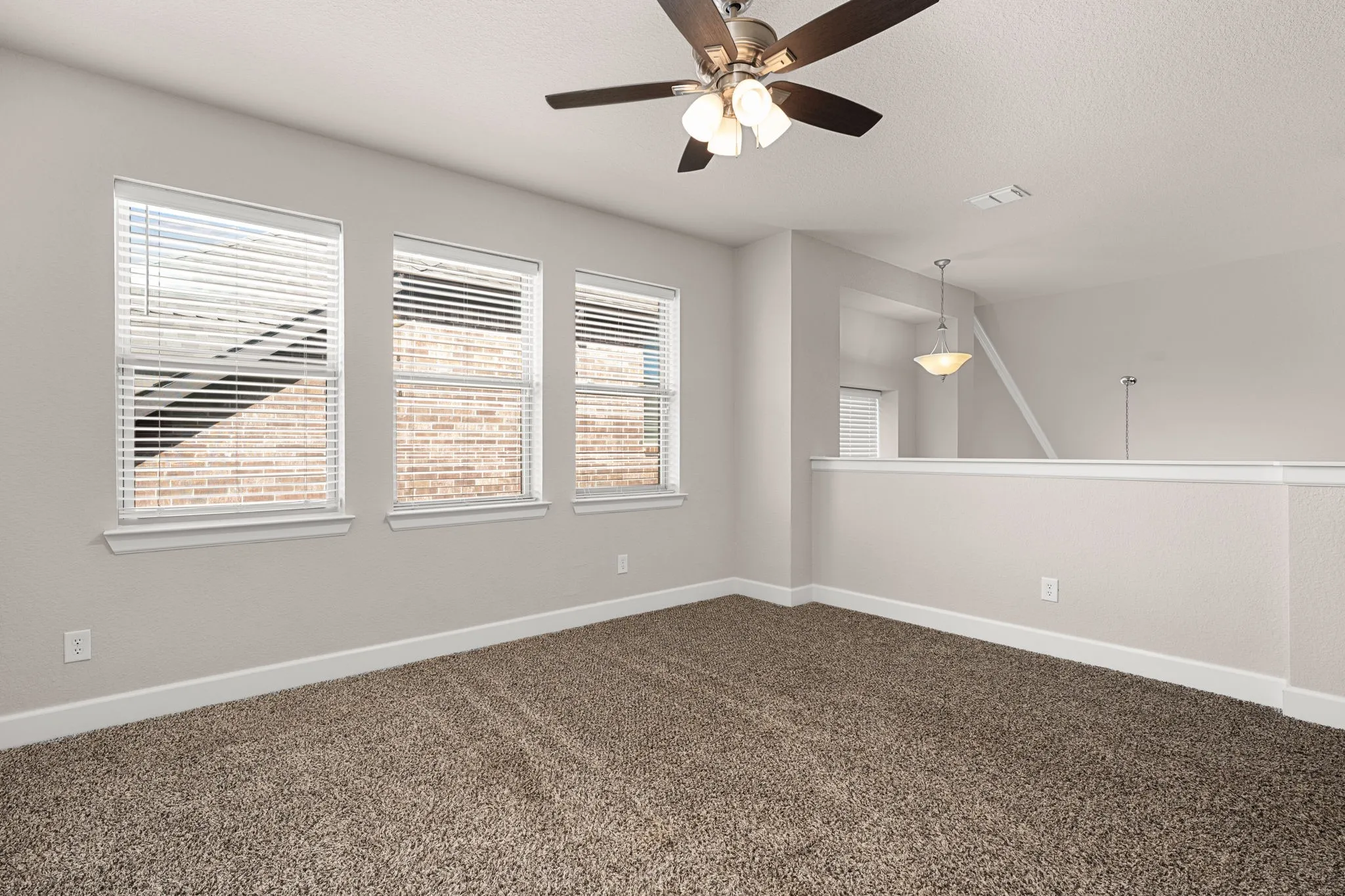 Unfurnished room featuring ceiling fan, dark carpet, and a textured ceiling