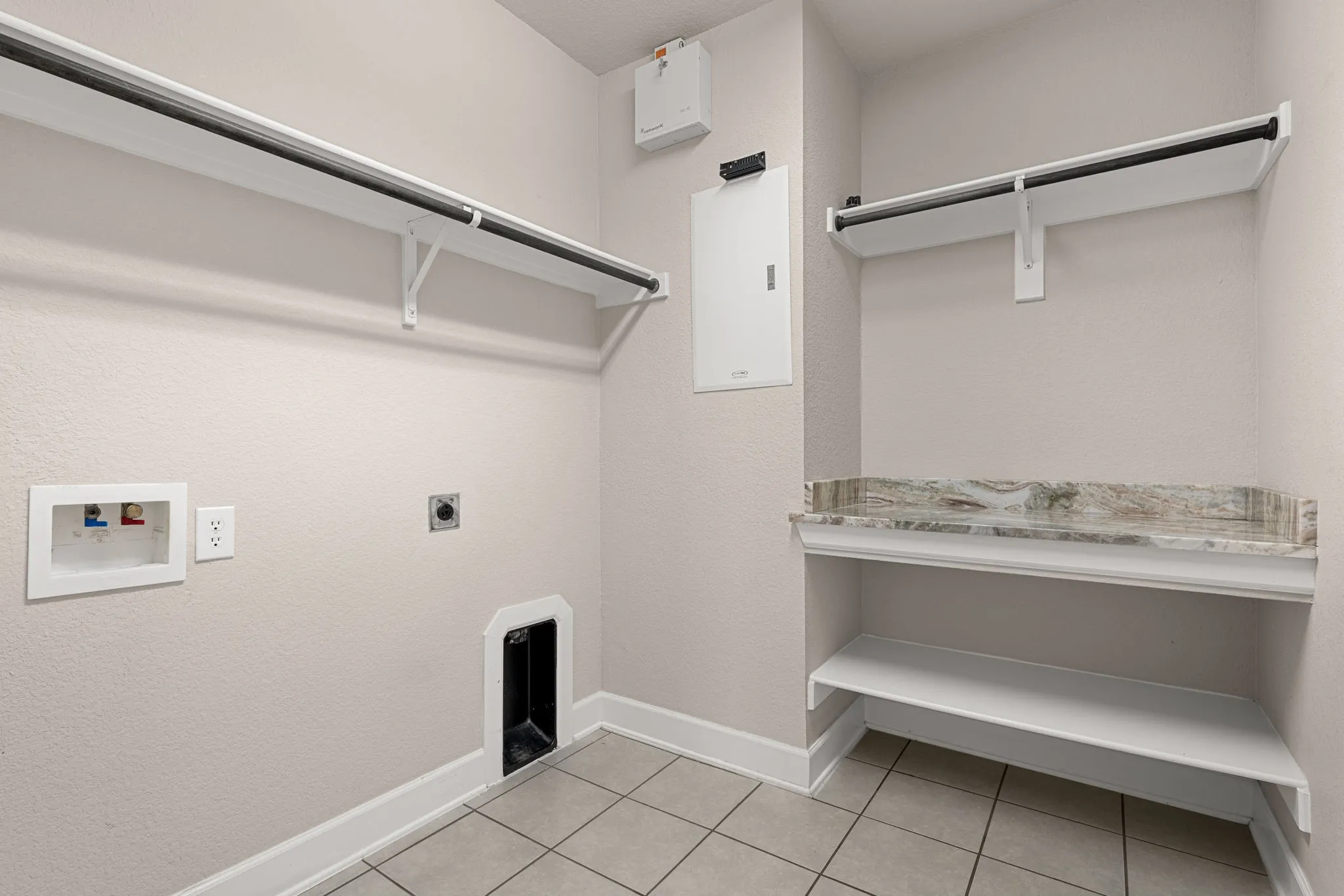 Laundry room featuring hookup for an electric dryer, light tile patterned floors, and washer hookup