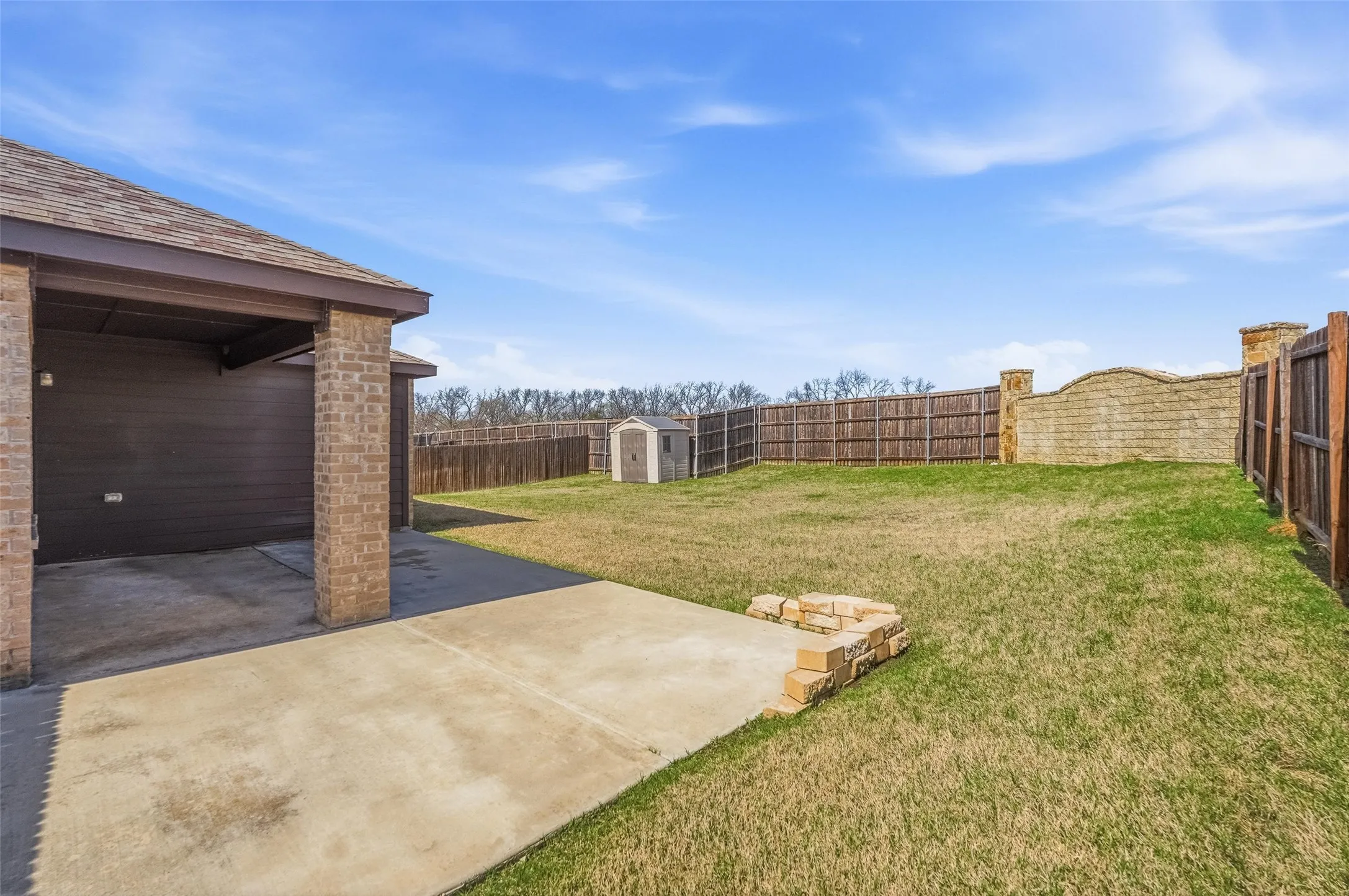 Large covered patio with extra concrete extension.