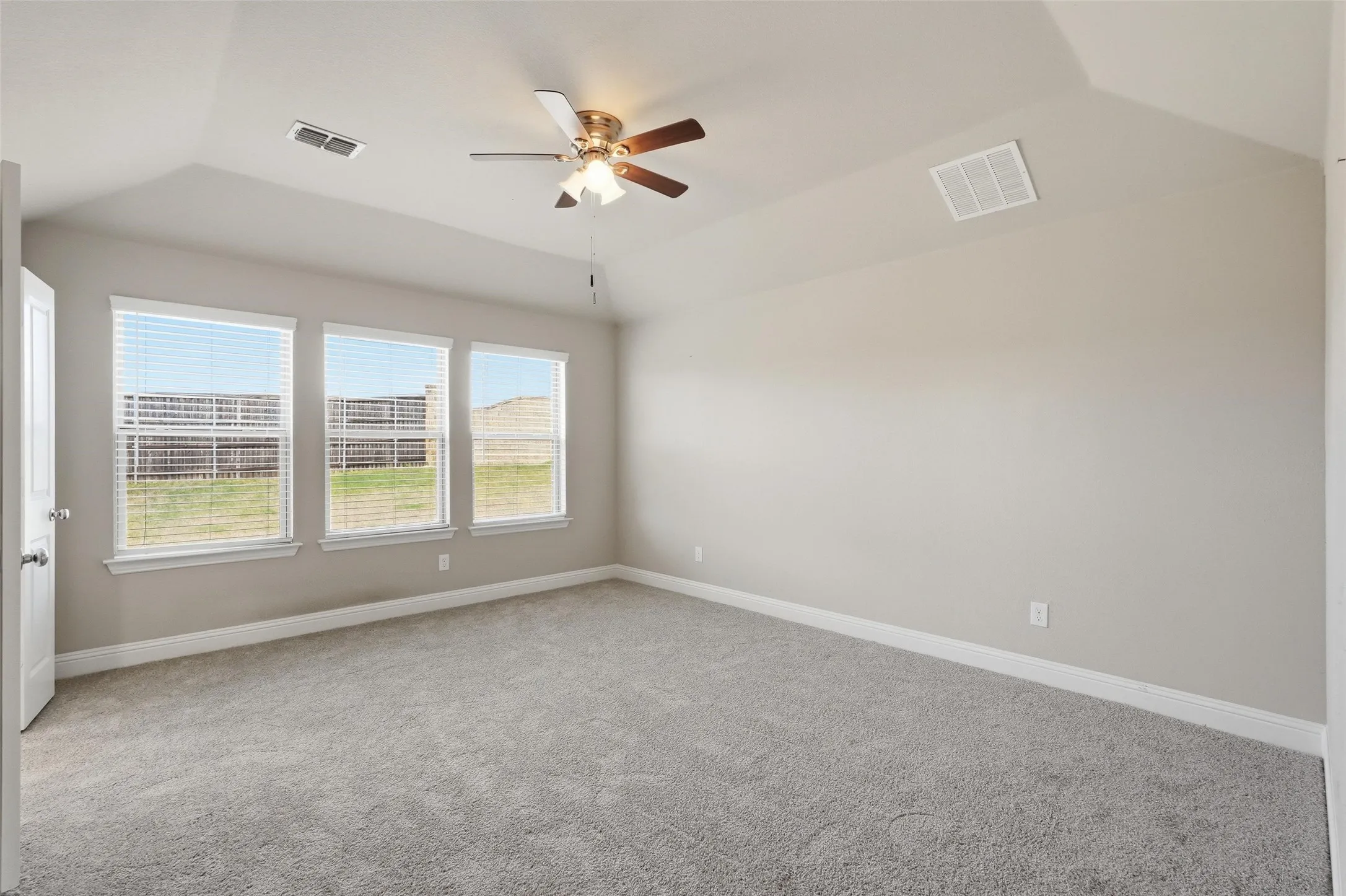 Large primary bedroom with new carpet and plenty of windows.