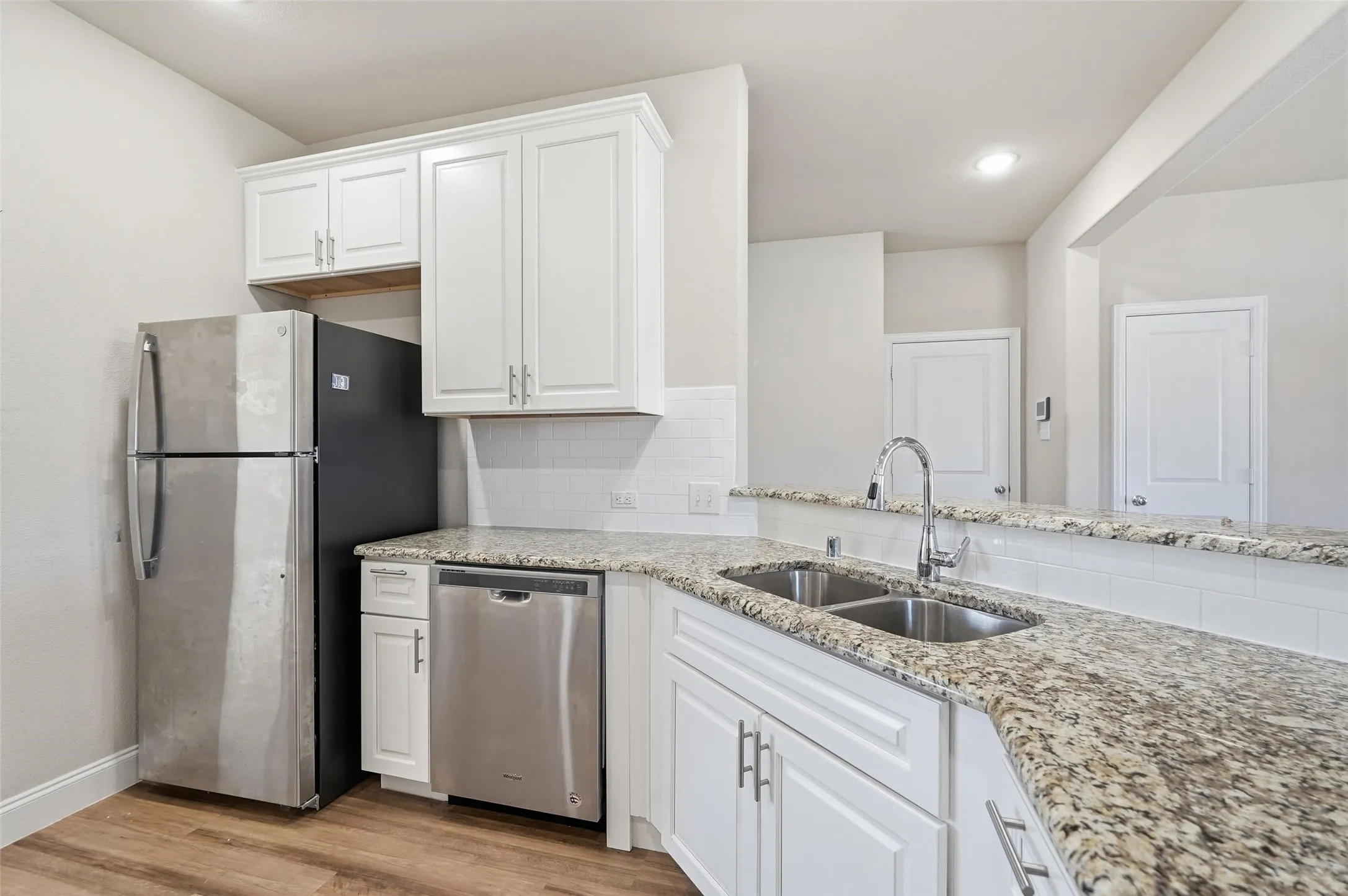 Kitchen with granite counter tops and stainless appliances opens to the large living space.