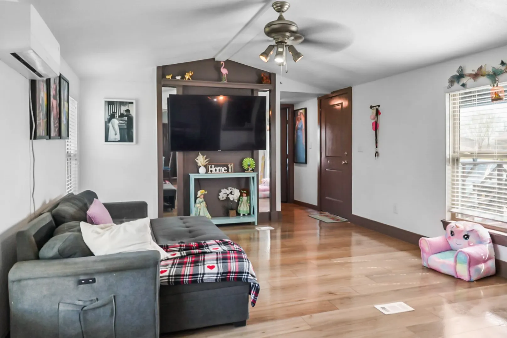 Living area featuring a ceiling fan, a mini split for heating / cooling, and wood finished floors