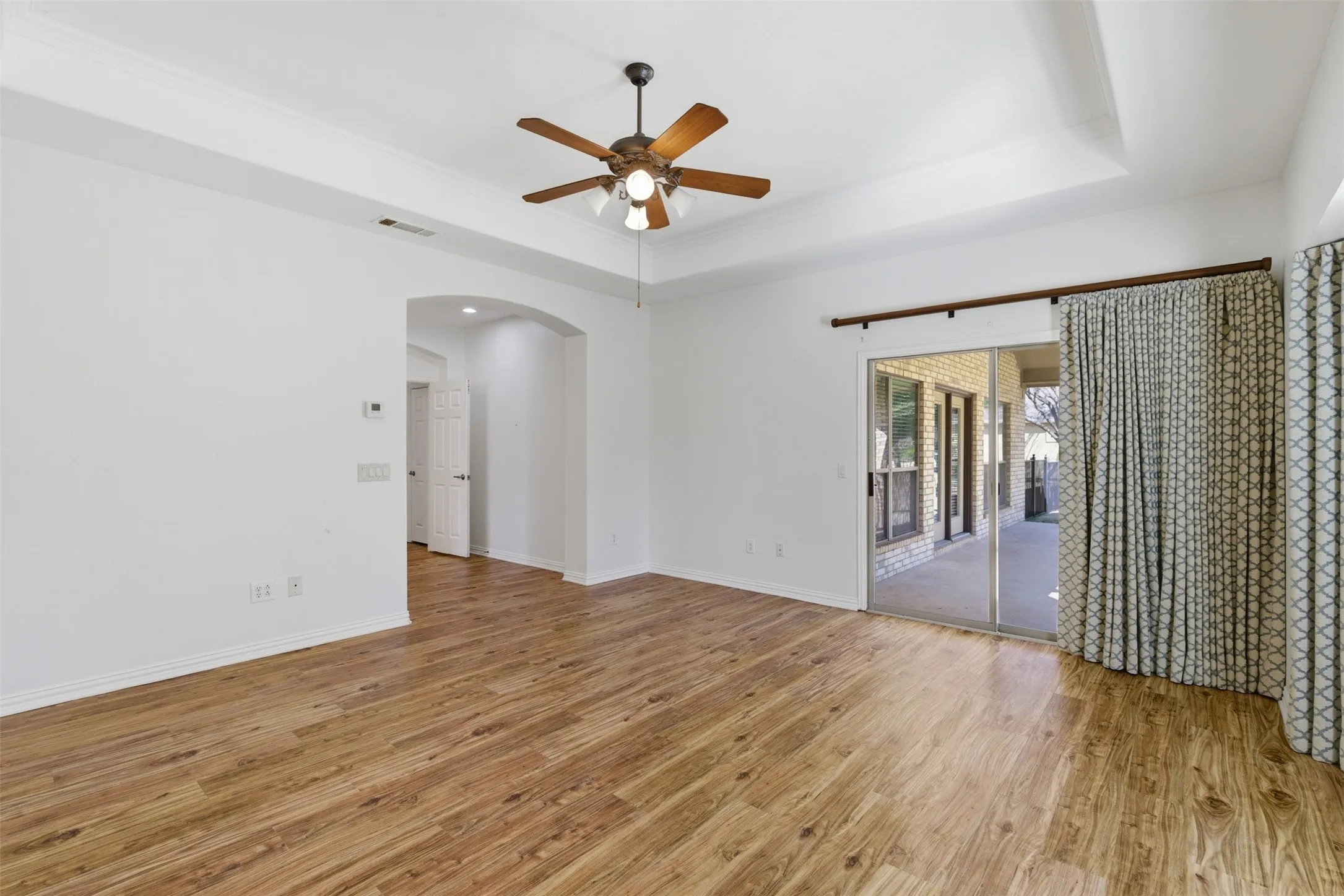 Patio doors in the primary bedroom open to the covered porch
