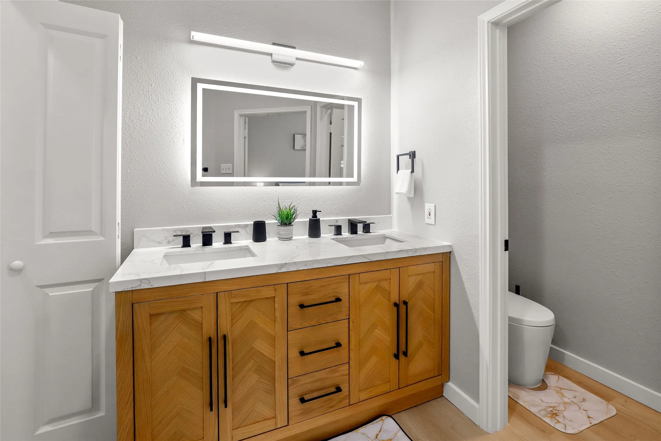 Full bathroom featuring double vanity and wood finished floors