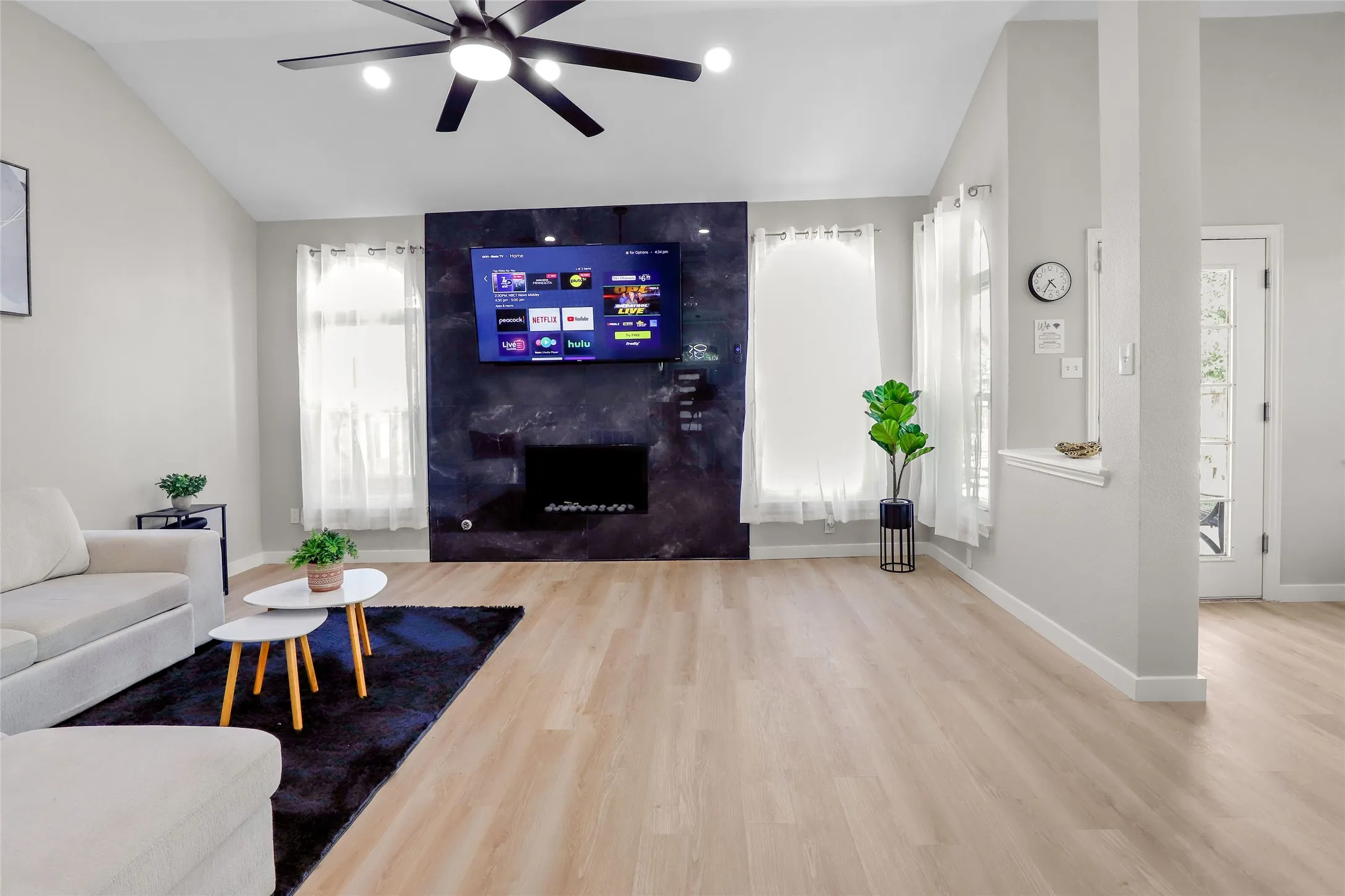 Living room featuring lofted ceiling, wood finished floors, and a ceiling fan