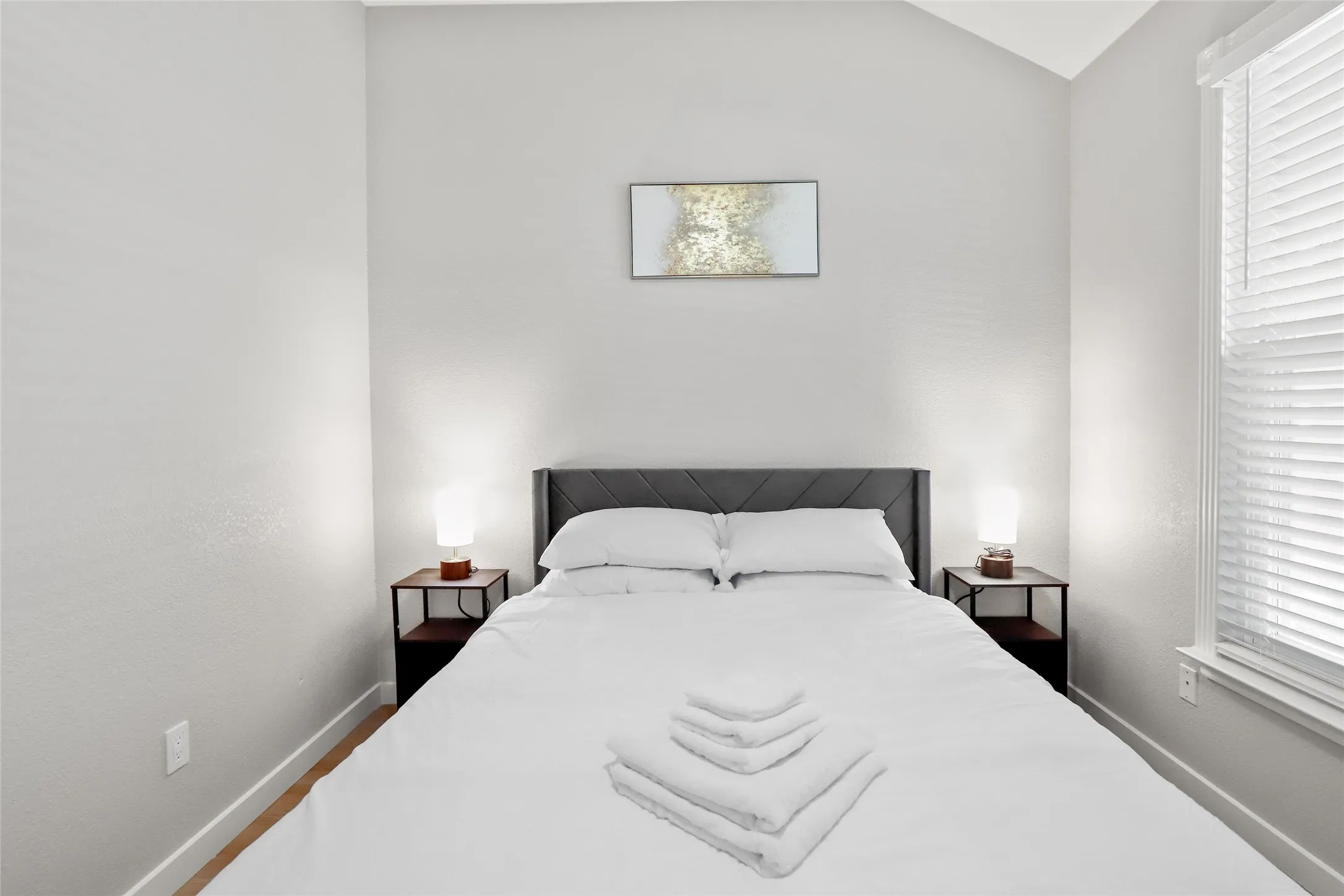 Bedroom with vaulted ceiling and multiple windows