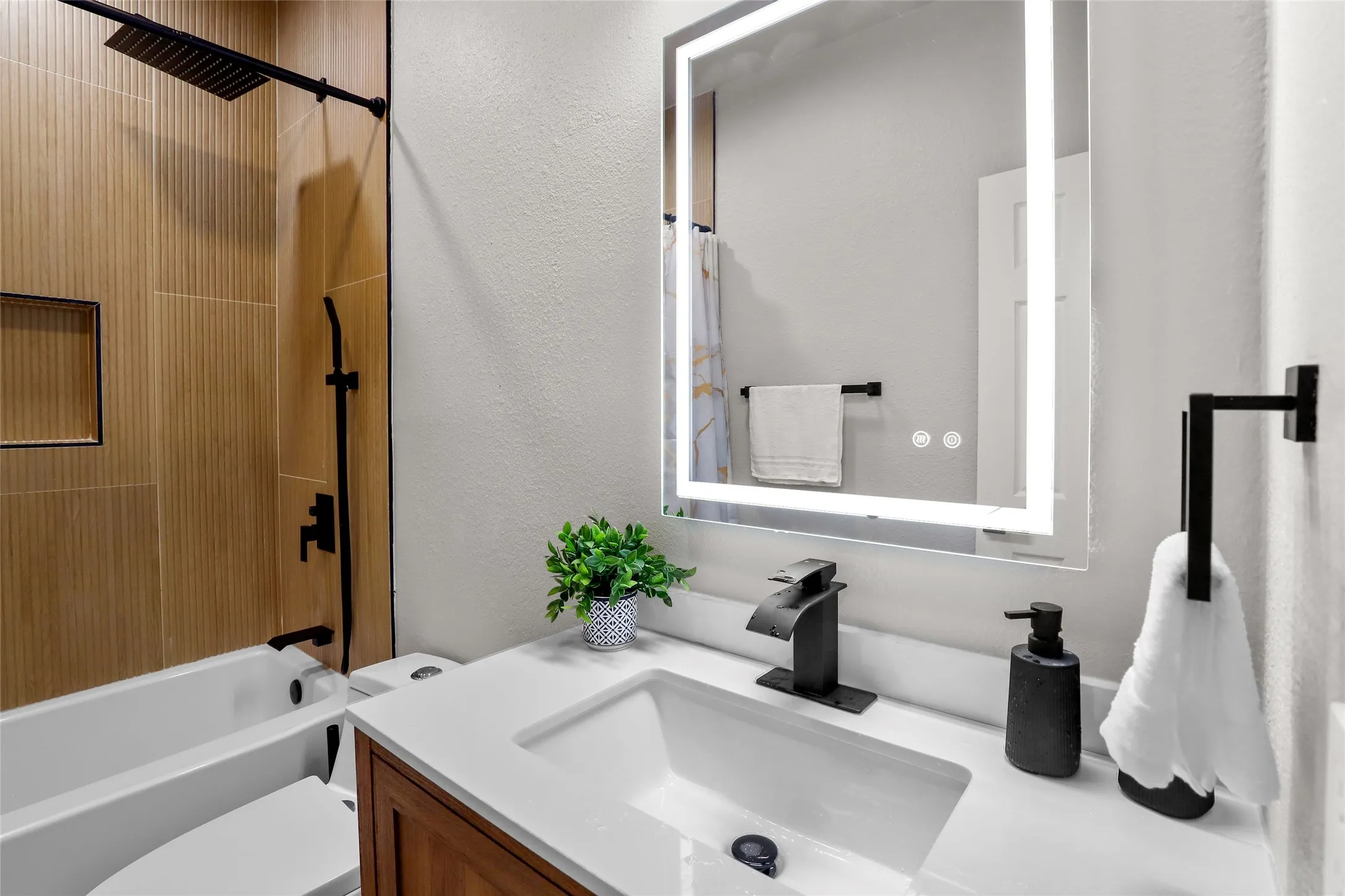 Full bathroom with vanity, bathtub / shower combination, and a textured wall