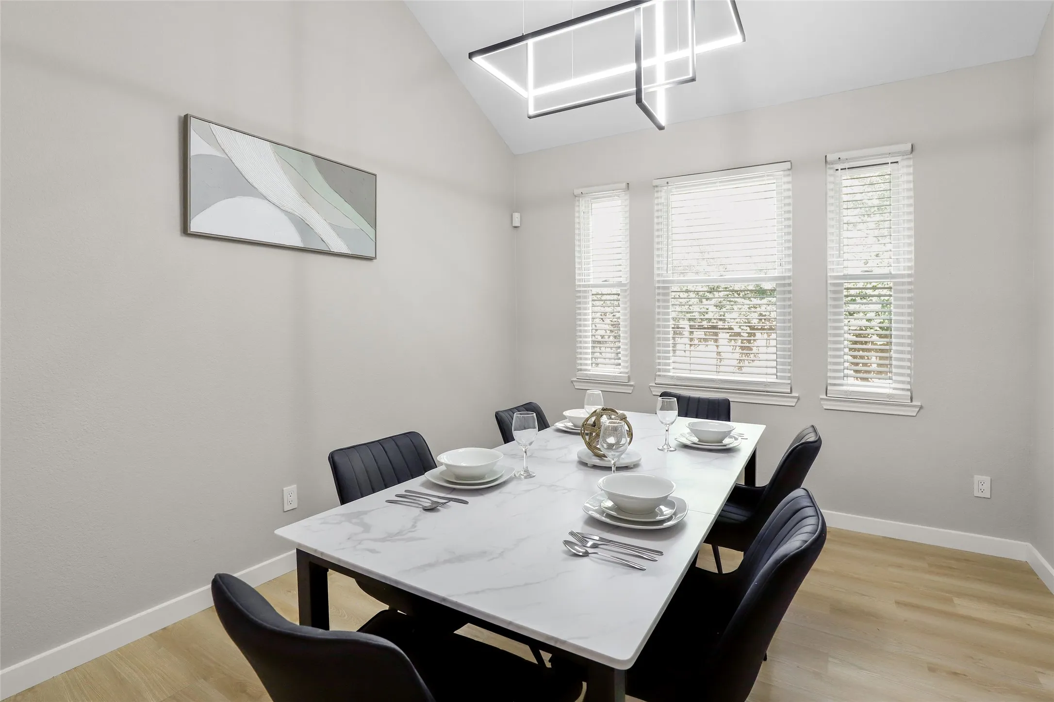Dining area featuring light wood-style floors, lofted ceiling, and a chandelier