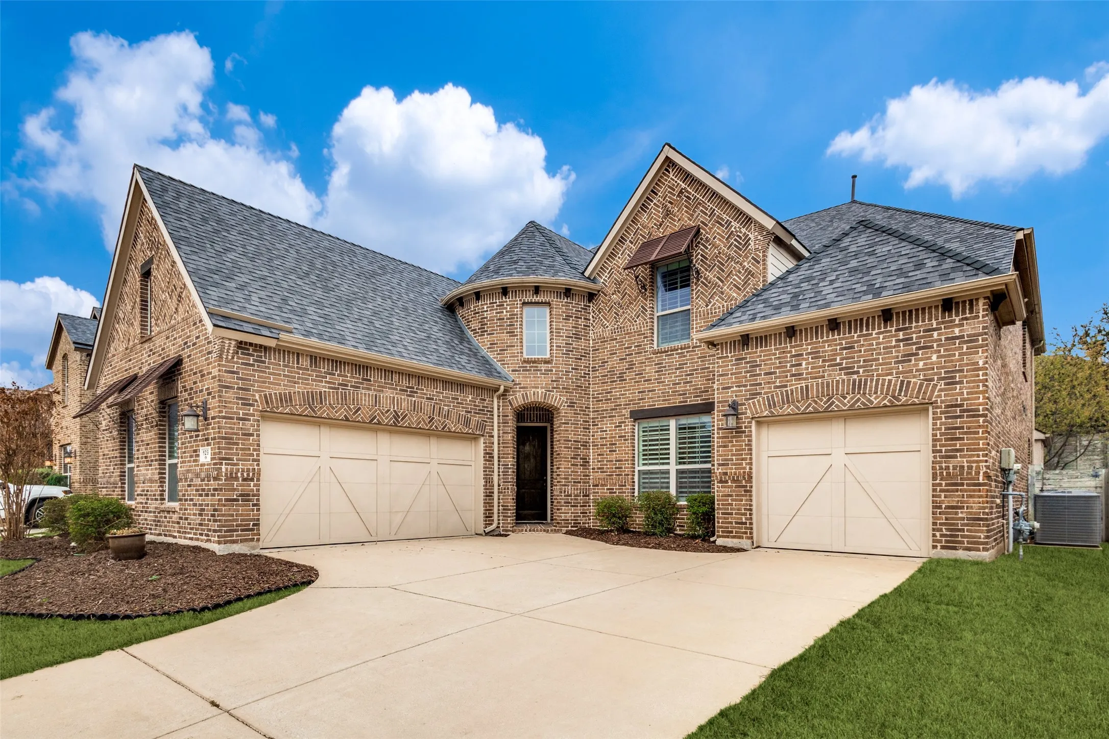 French provincial home featuring brick siding and a shingled roof
