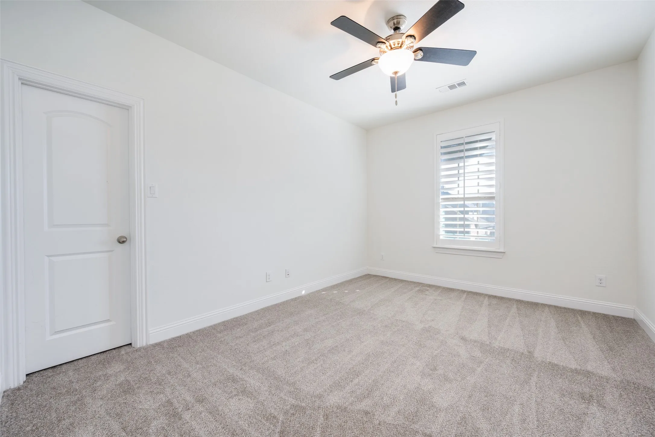 Unfurnished room with light colored carpet and ceiling fan