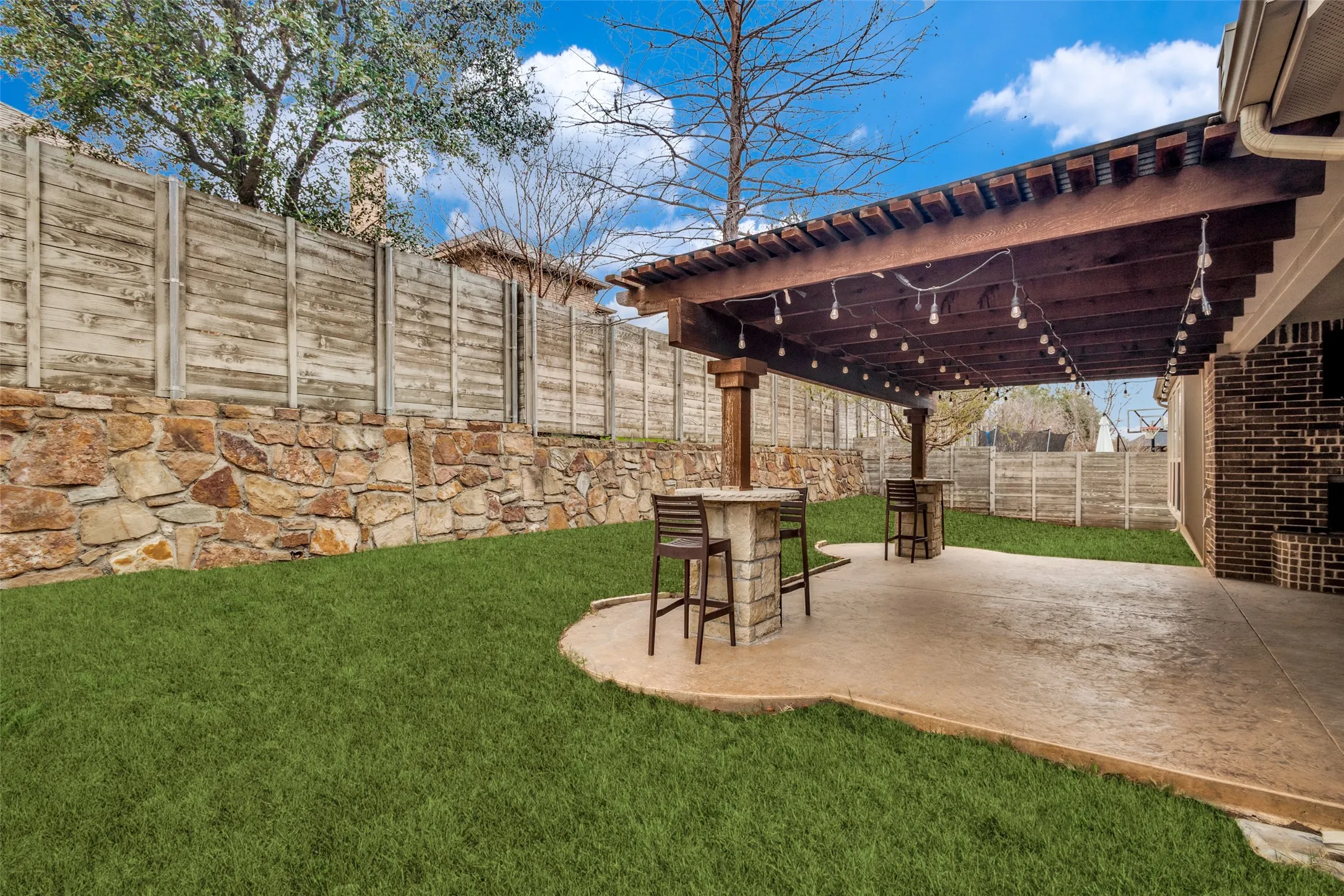 Fenced backyard with a pergola and a patio area