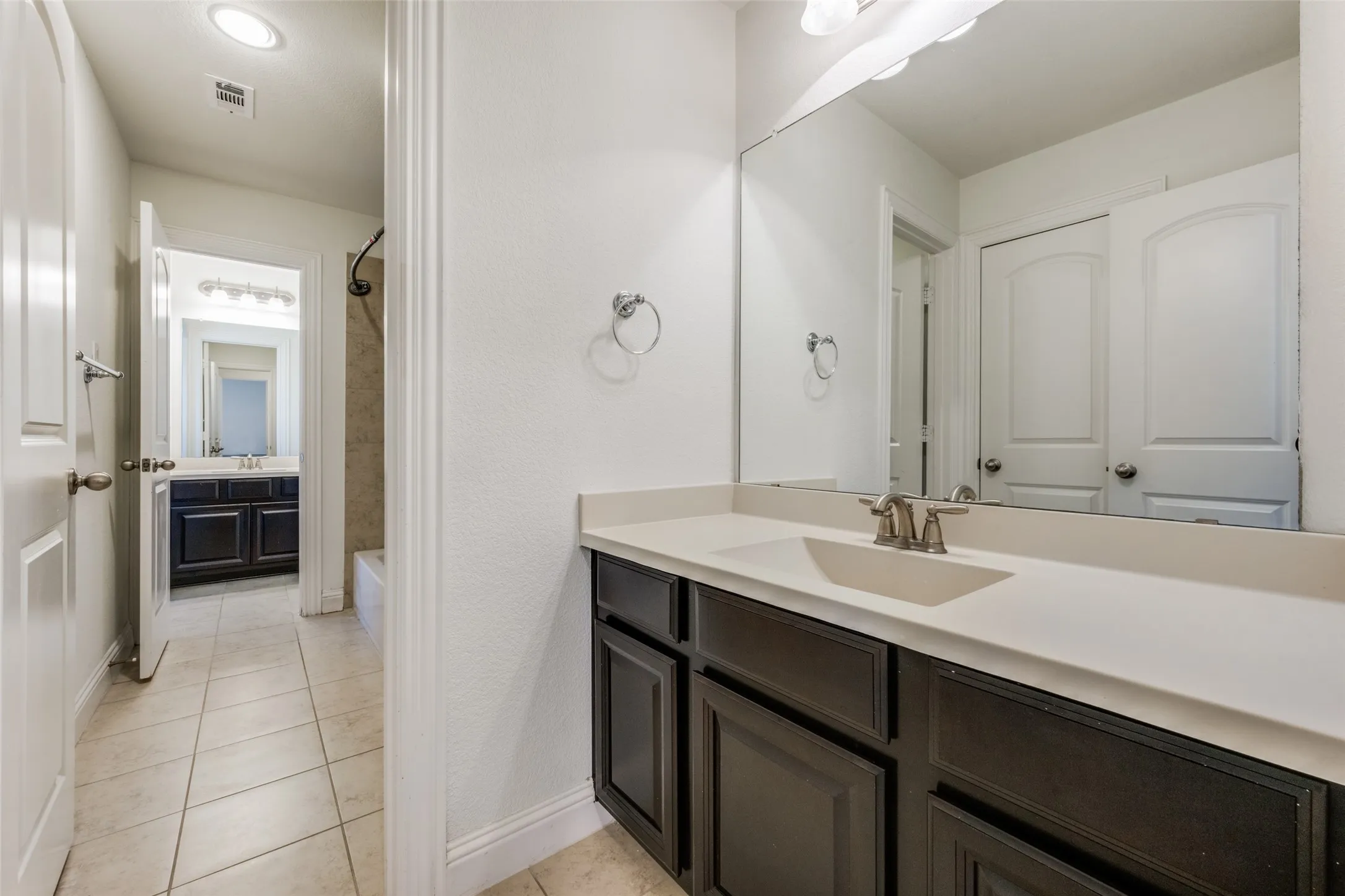 Full bath with vanity, shower / bathtub combination with curtain, and light tile patterned floors