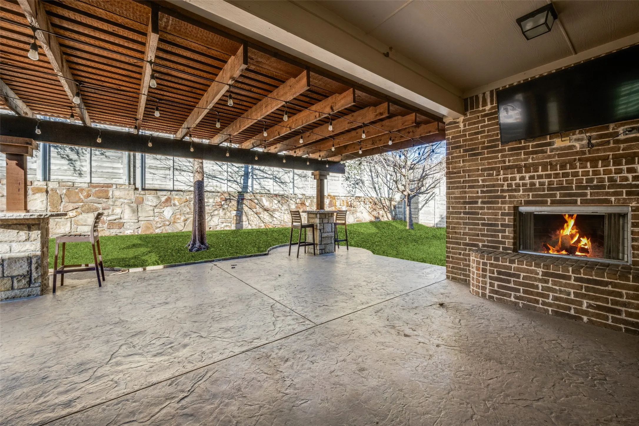 View of patio featuring an outdoor brick fireplace
