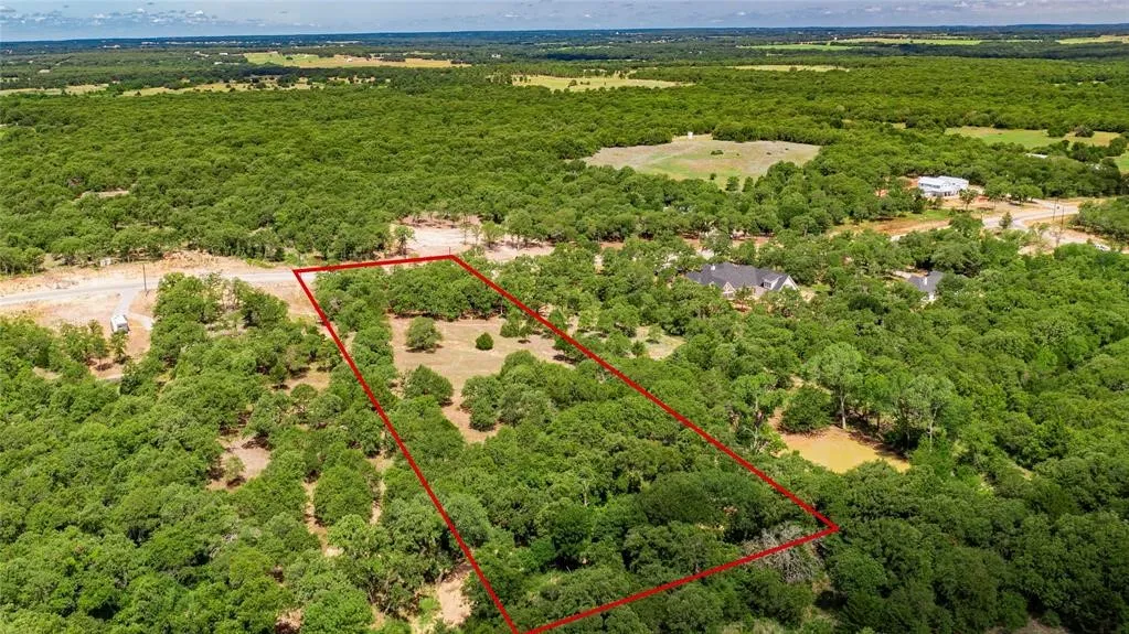 Aerial view of the 2-acre lot offering lots of trees and beautiful rolling terrain.