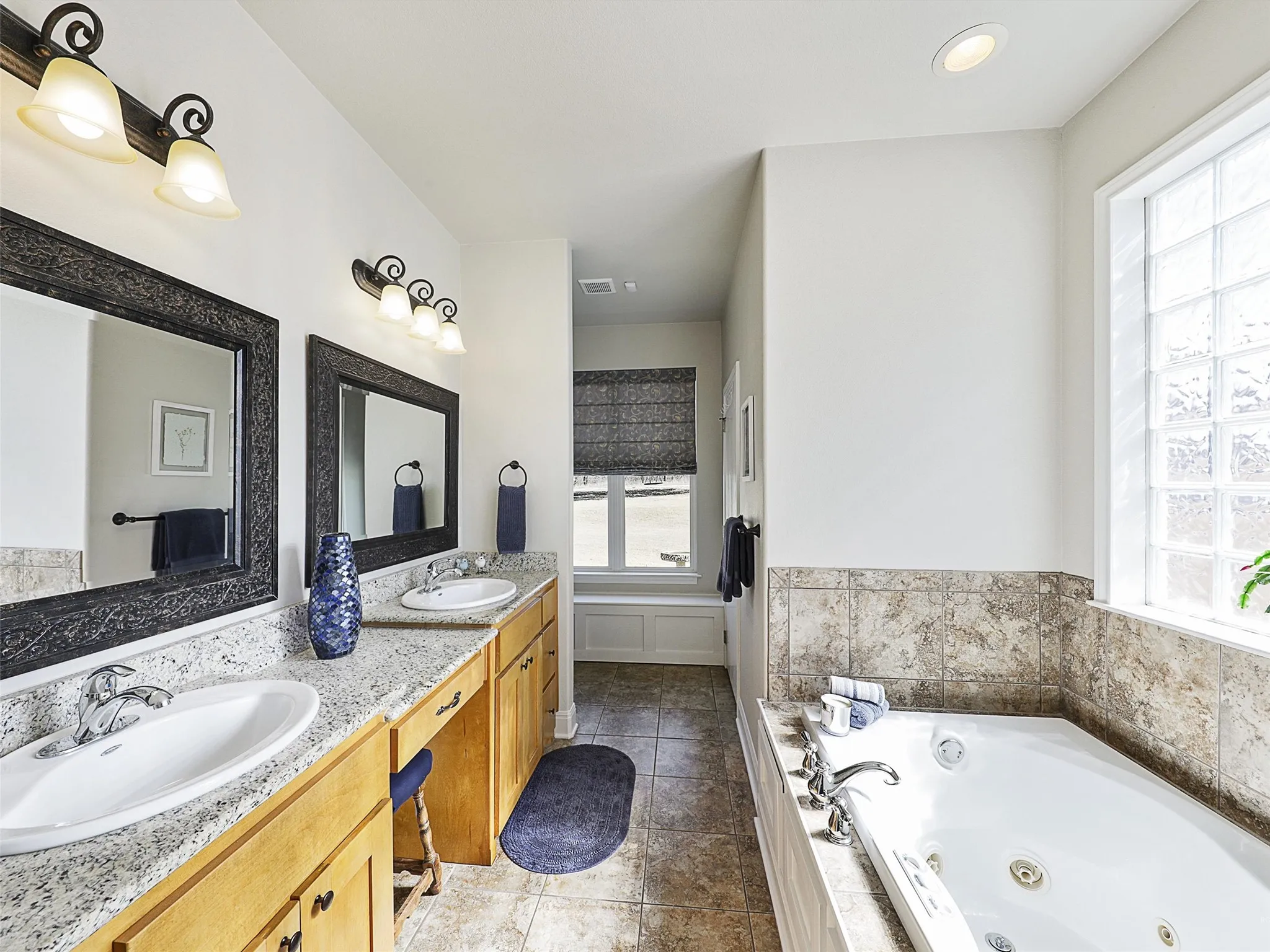 Primary Bath with Maple Cabinets, Double Vanities, Make Up Area and Large Jetted Tub.