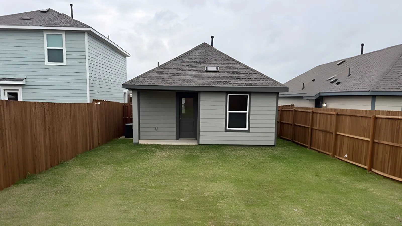 Back of property featuring roof with shingles and a fenced backyard