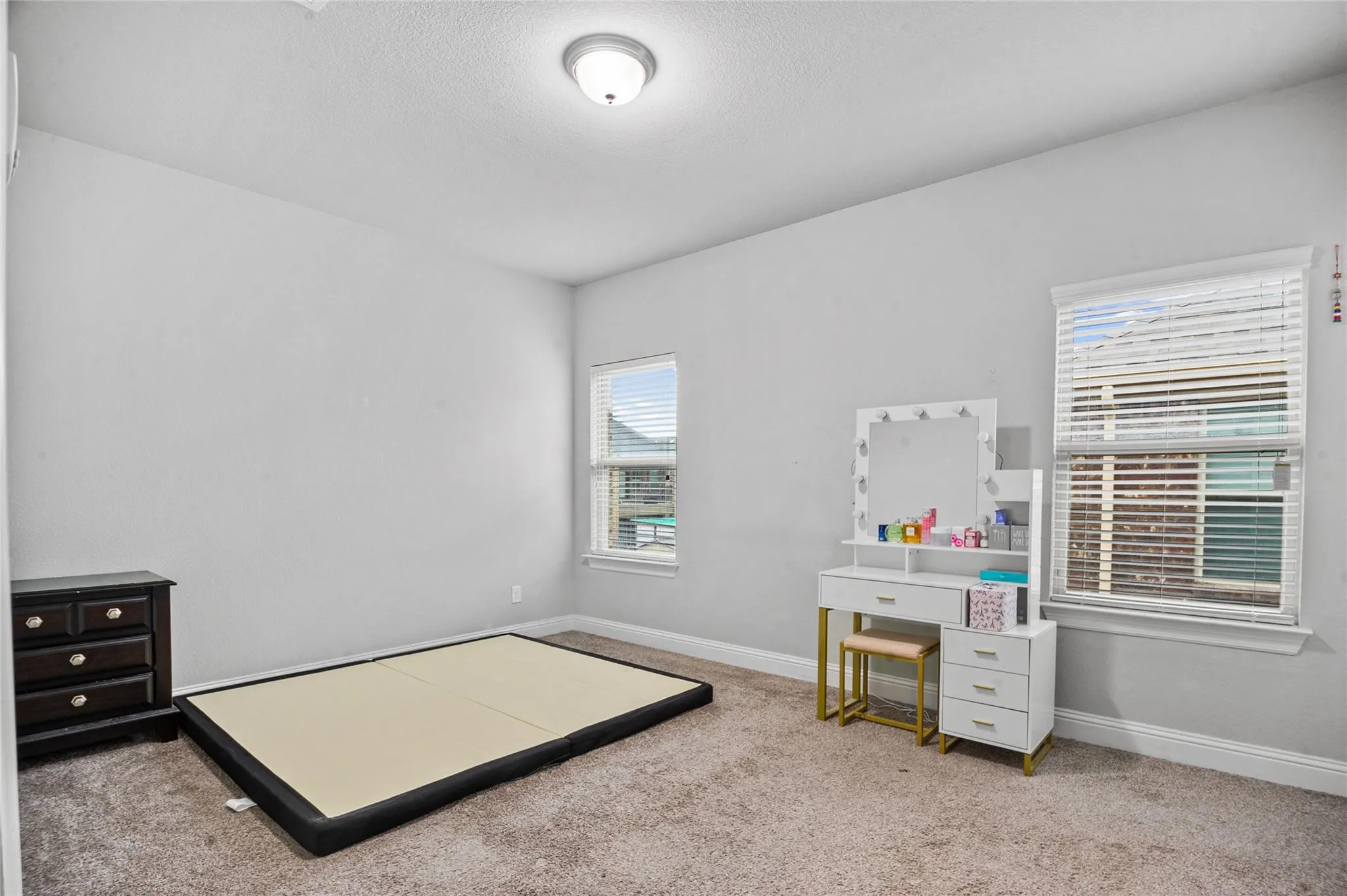 Bedroom featuring light colored carpet and a textured ceiling