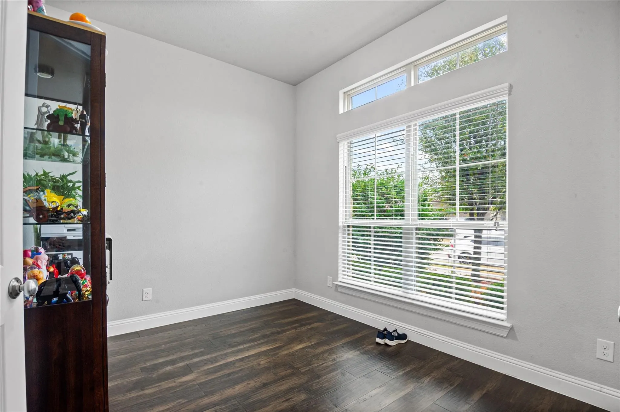 Empty room featuring baseboards and dark wood-type flooring