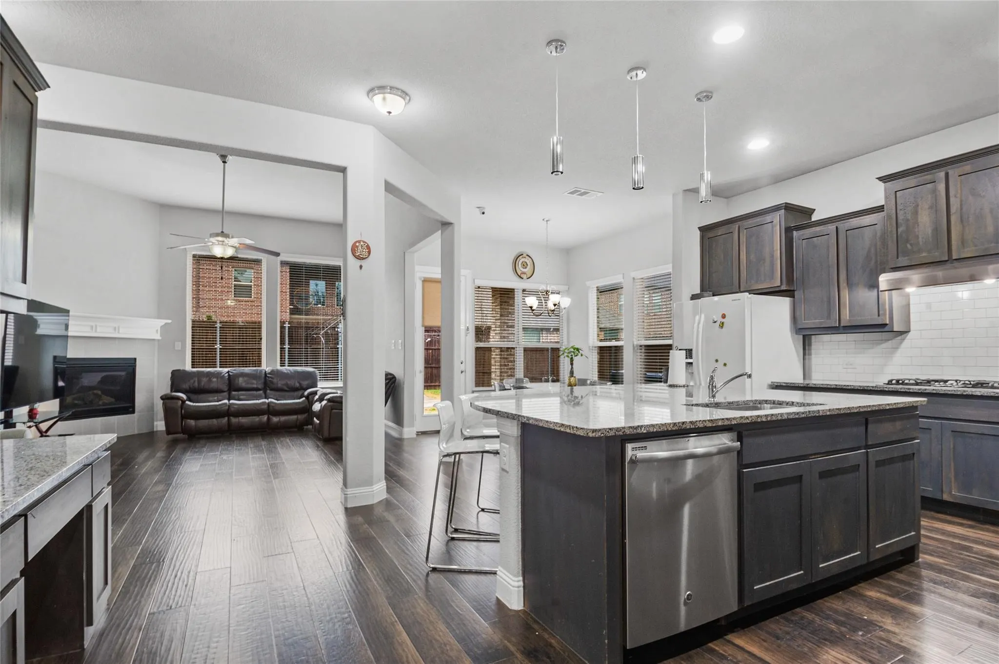 Kitchen with light stone counters, stainless steel appliances, a ceiling fan, and backsplash