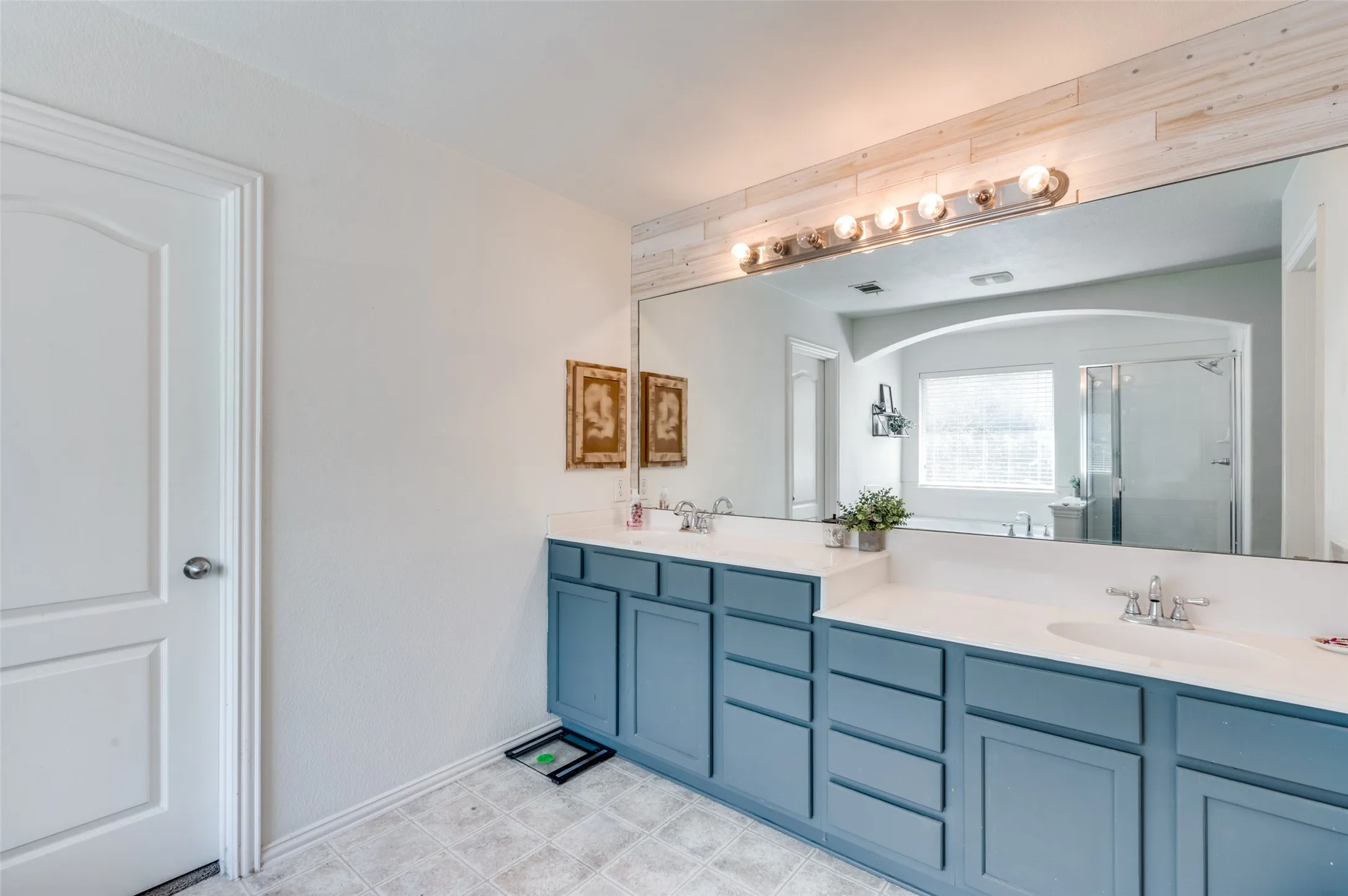 Primary bathroom includes designer cabinets and double vanity with plenty of of storage and space.