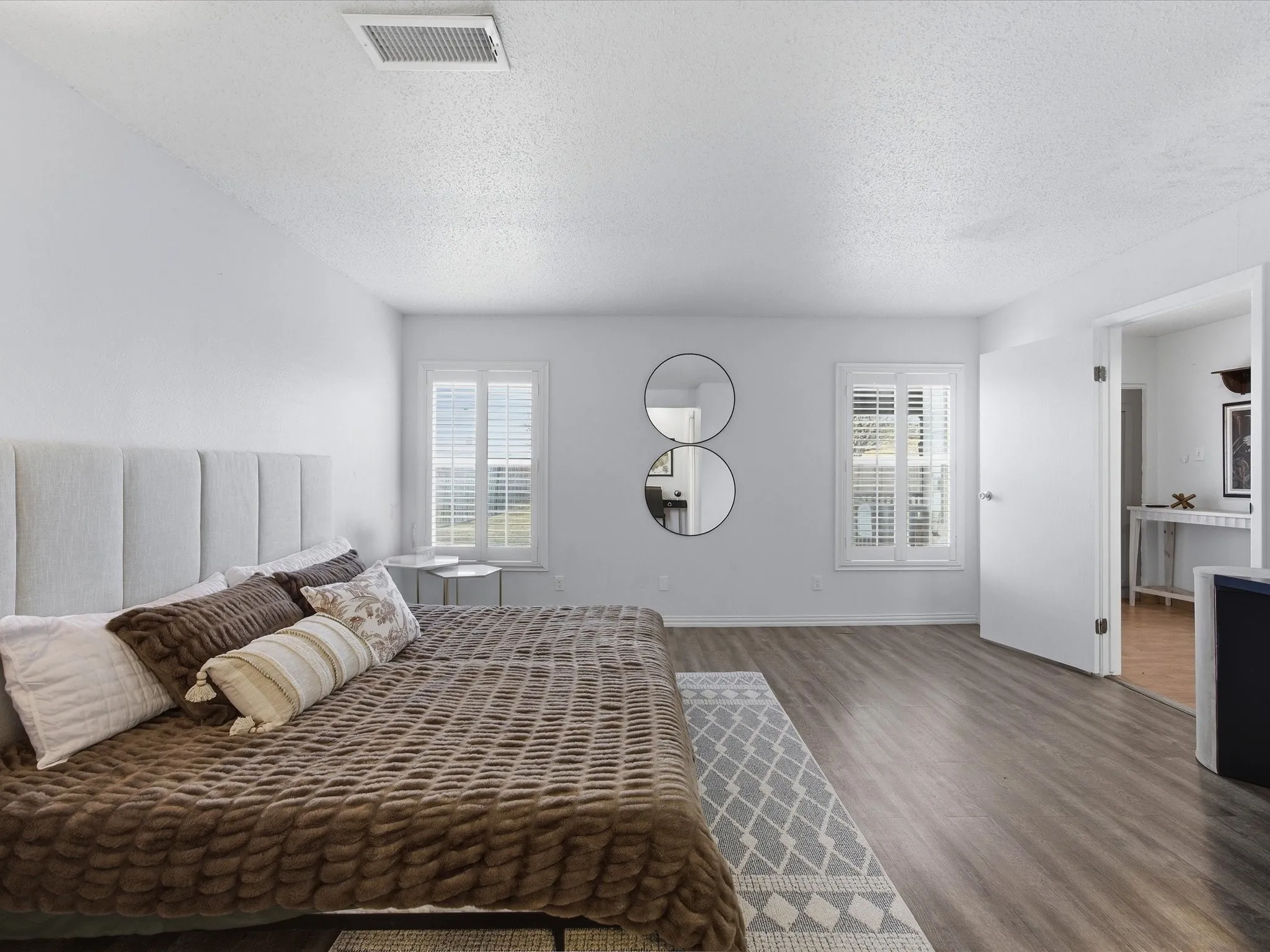 Primary Bedroom featuring a textured ceiling, dark wood finished floors, and ensuite bathroom