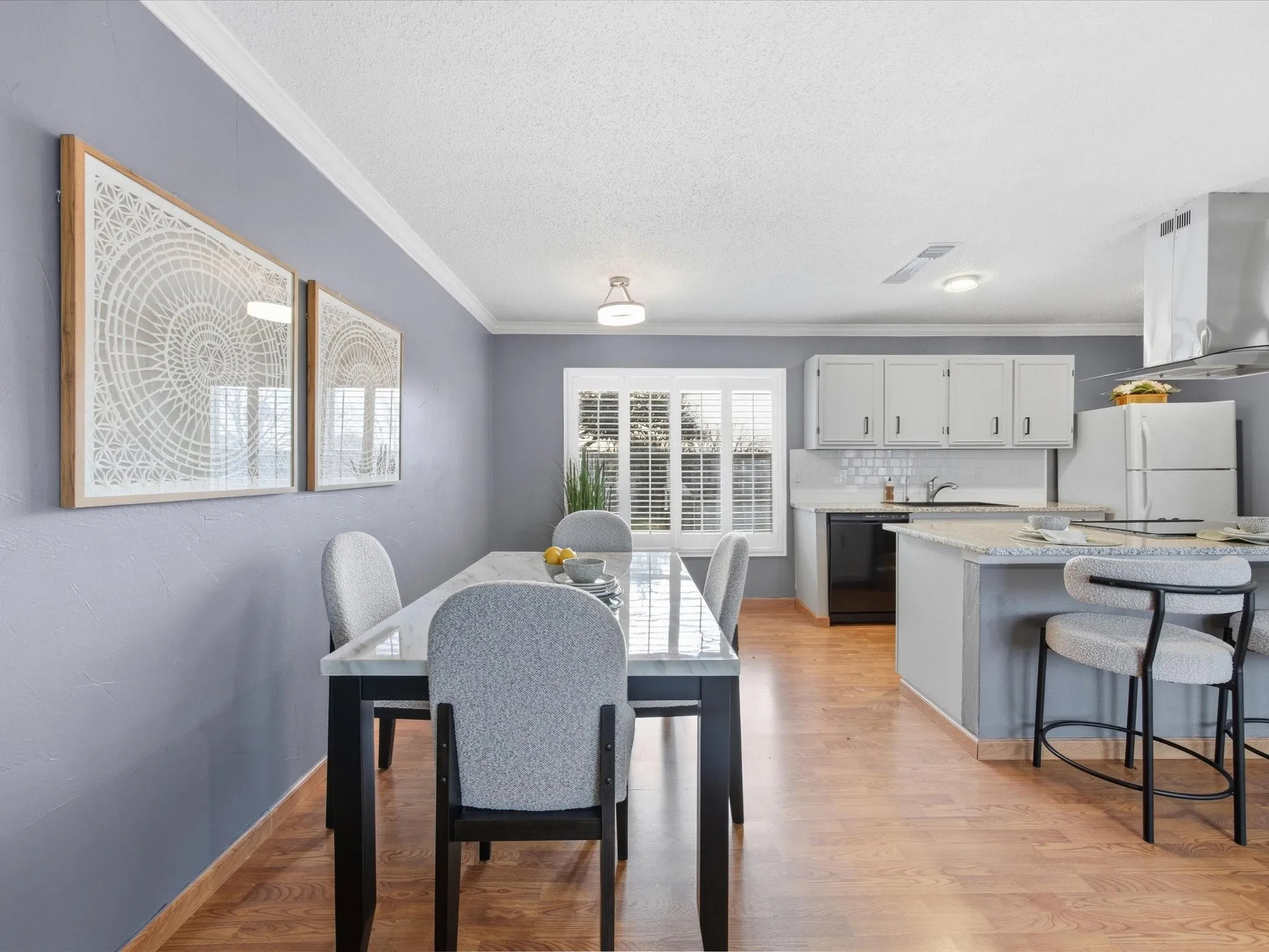 Dining room featuring crown molding, light wood-style floors, and a textured ceiling