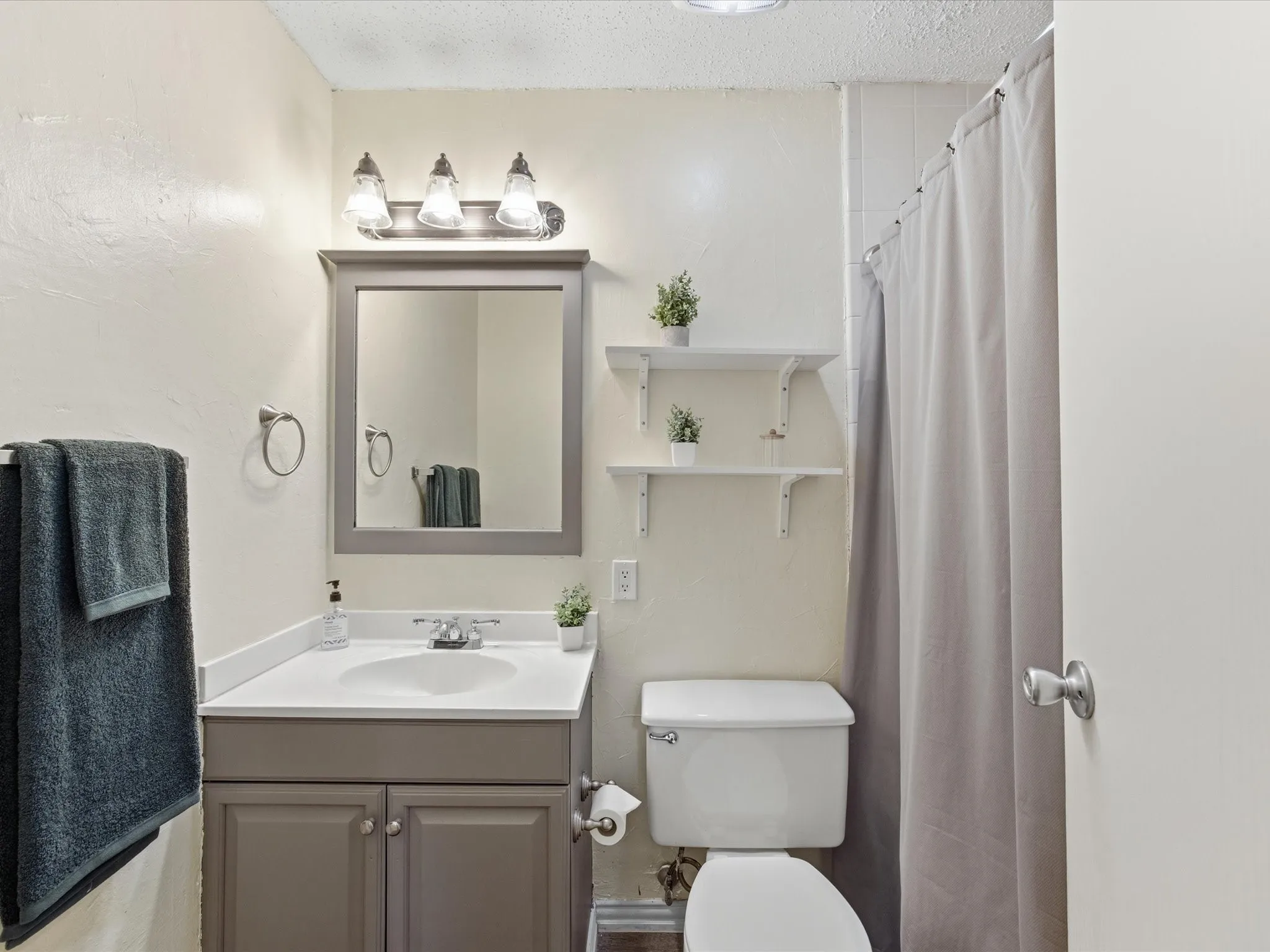 Primary Bedroom featuring a textured ceiling, dark wood finished floors, and ensuite bathroom