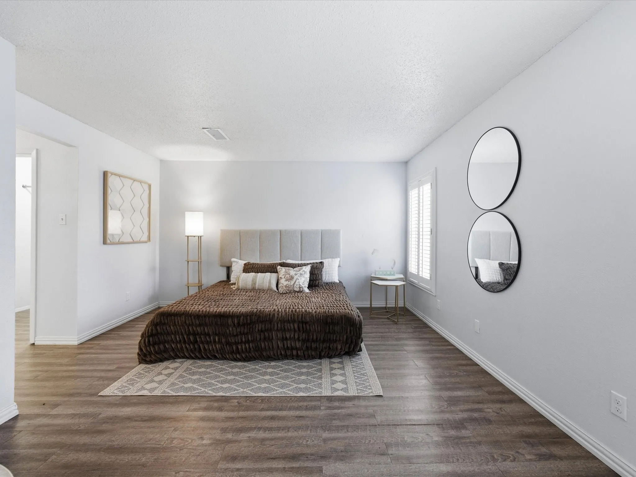 Primary bedroom featuring wood finished floors and an office area