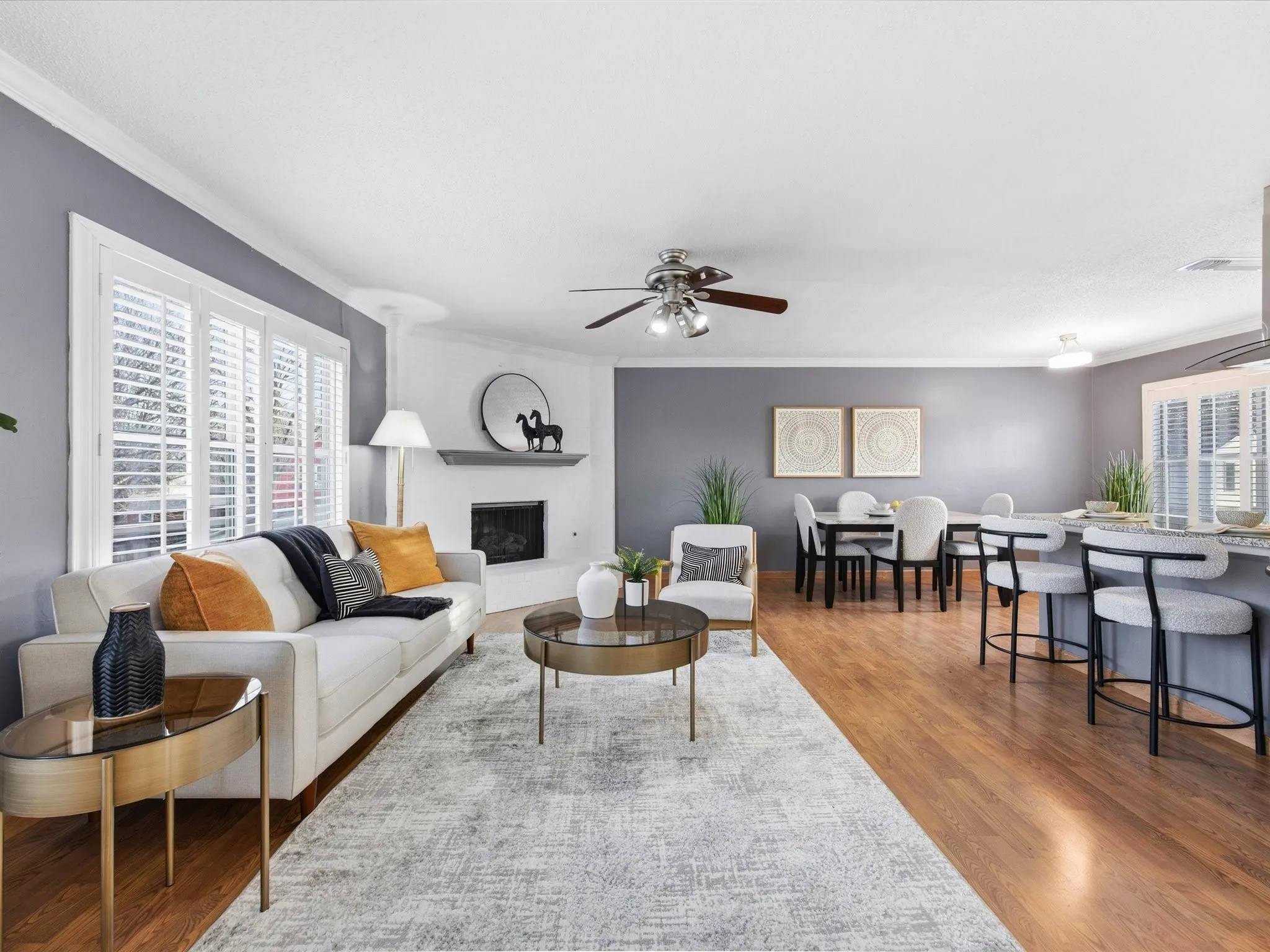 Living room featuring a ceiling fan, ornamental molding, healthy amount of natural light, and light wood finished floors