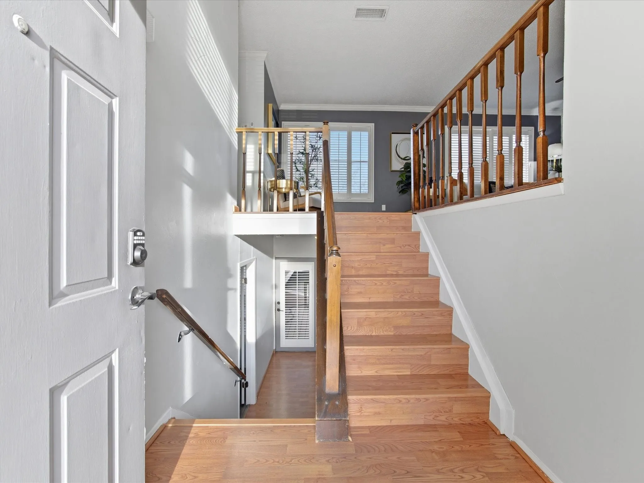 Stairway featuring ornamental molding and wood finished floors
