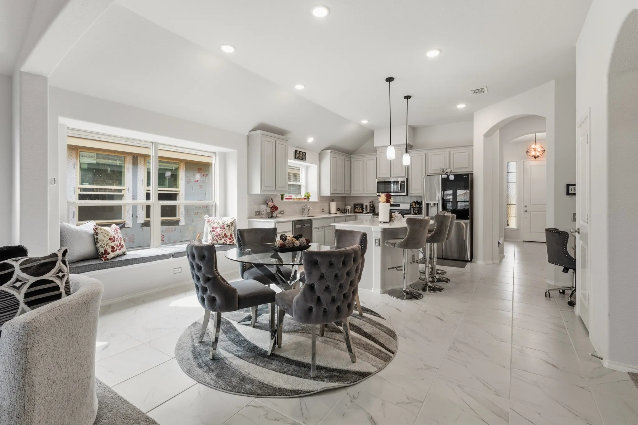 Dining space with arched walkways, light marble finish flooring, recessed lighting, and vaulted ceiling