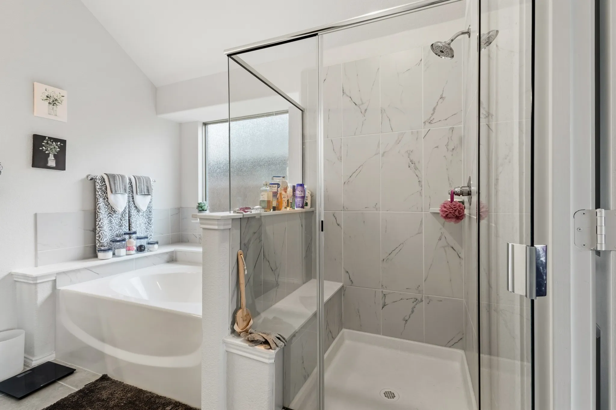 Bathroom with a marble finish shower, a garden tub, and vaulted ceiling