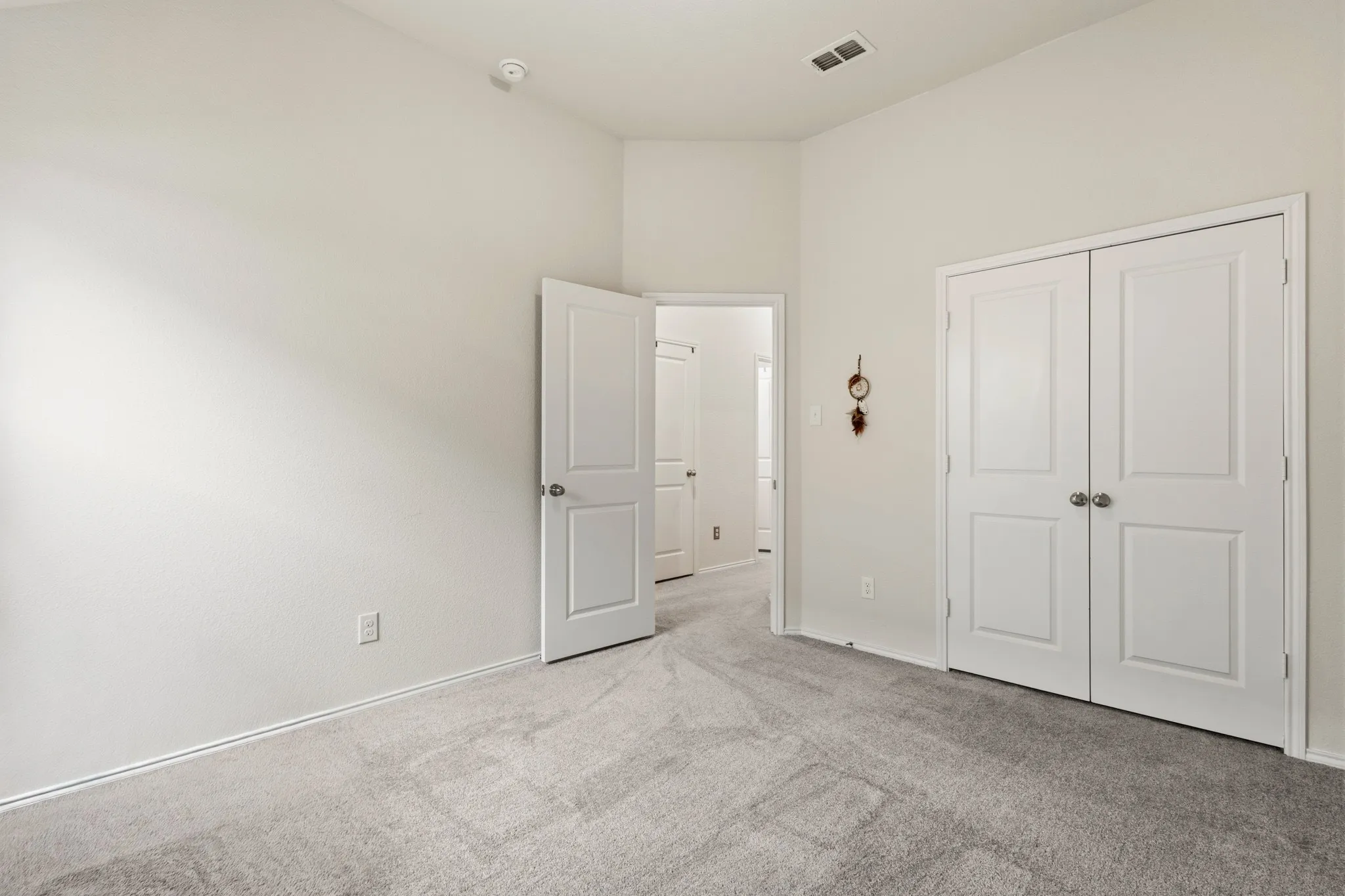 Unfurnished bedroom with light colored carpet and a closet