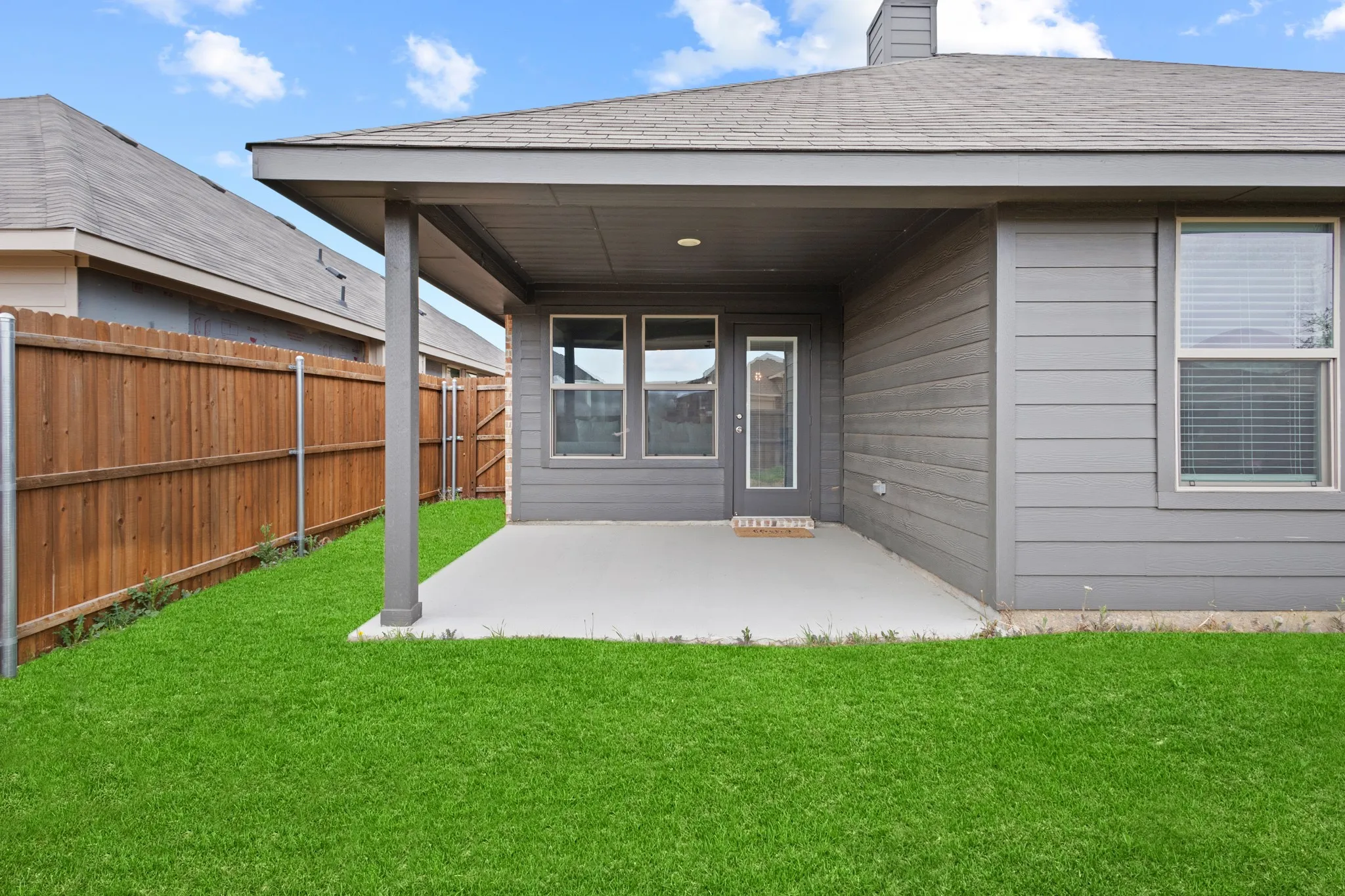 Back of property with a patio area, a fenced backyard, roof with shingles, and a chimney