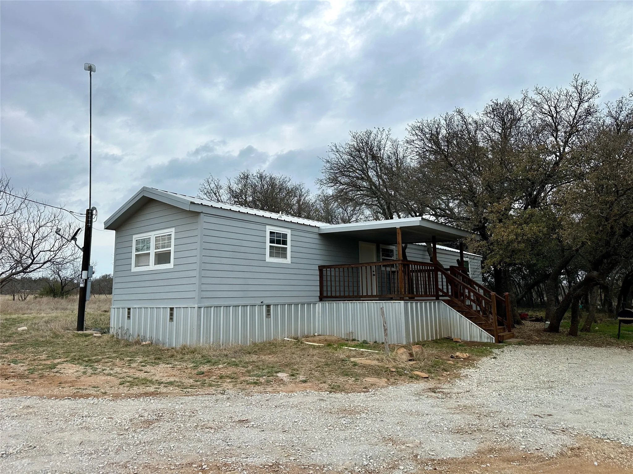 View of front of house featuring a metal roof and stairway