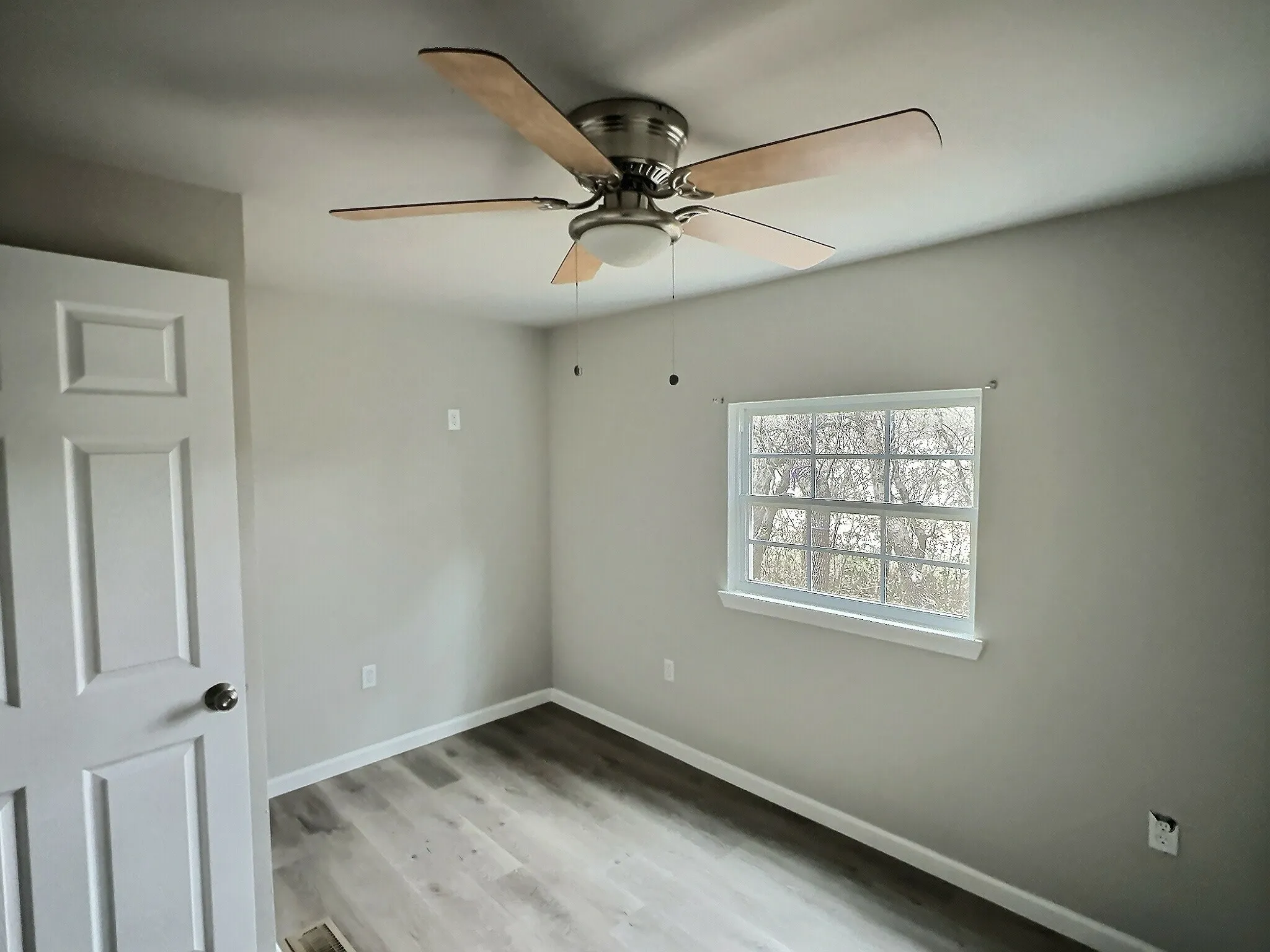 Unfurnished room featuring light wood-style flooring and ceiling fan