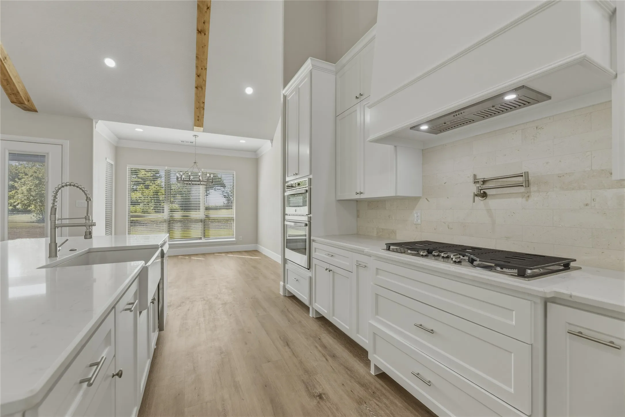View of dining area and gas cook top with pot filler.