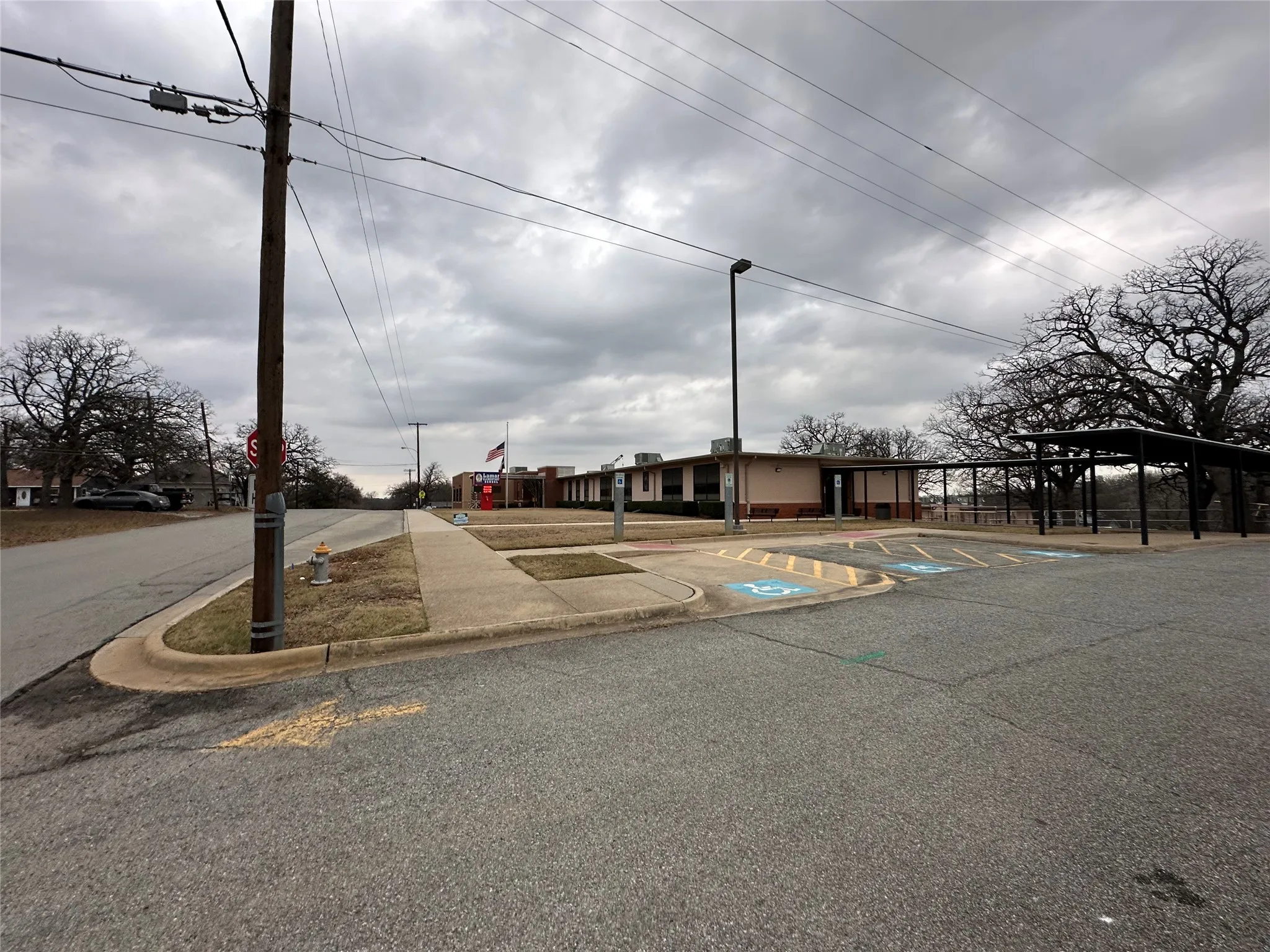 View of asphalt street featuring curbs and traffic signs