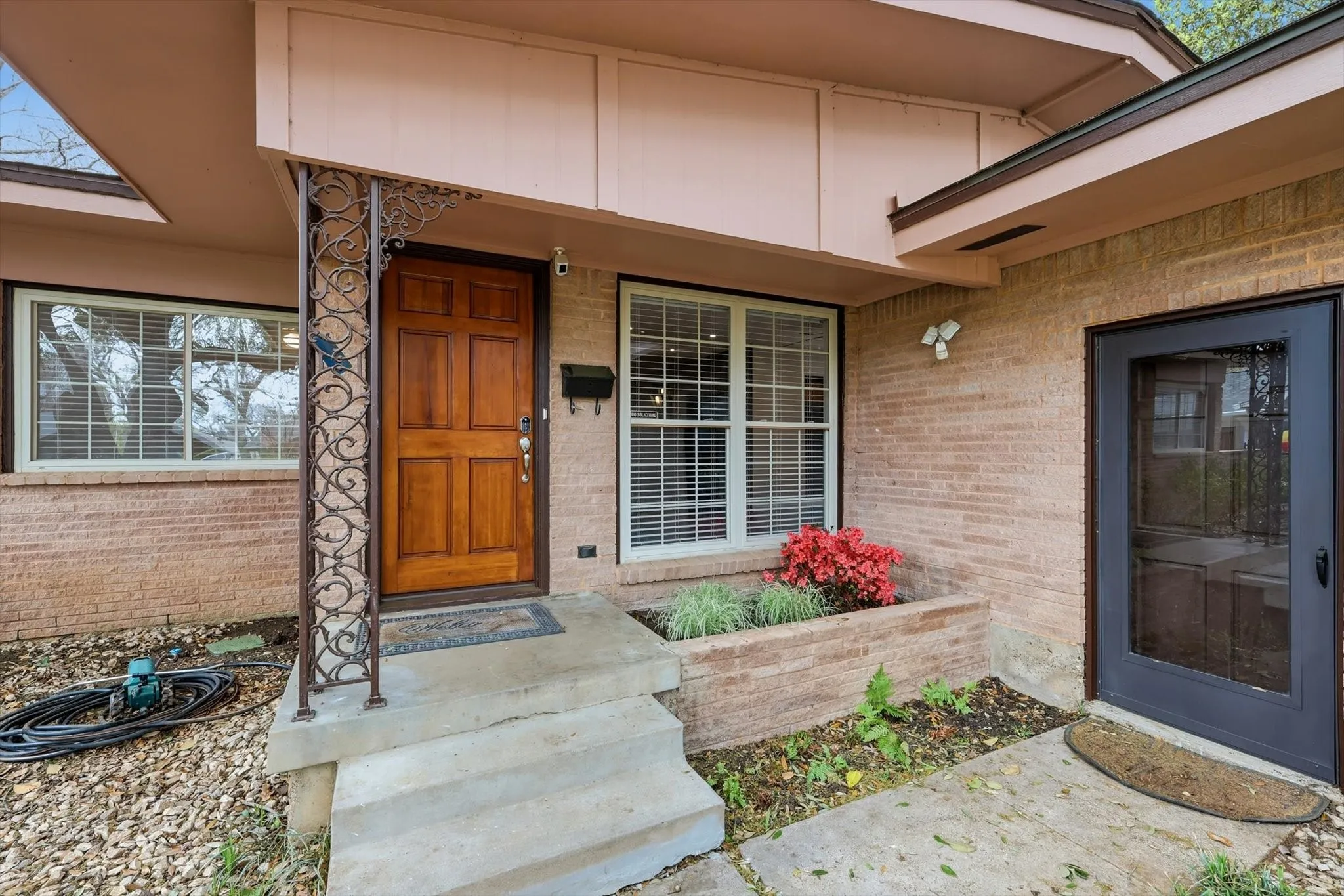 Entrance to property with brick siding and covered porch