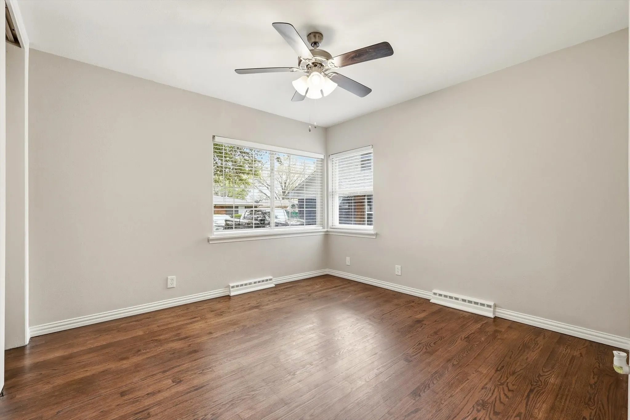 Spare room featuring dark wood finished floors and a ceiling fan