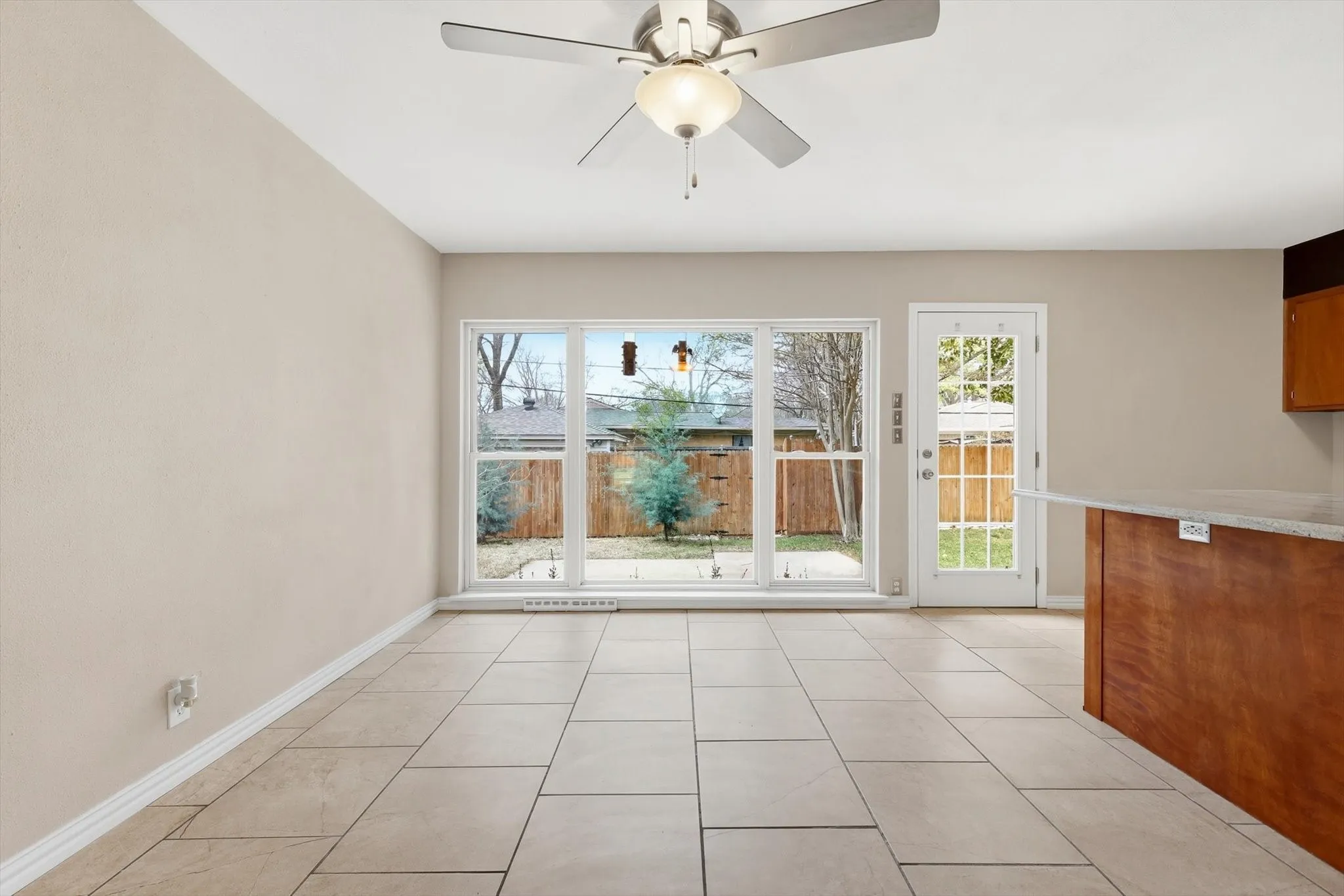 Unfurnished dining area with a ceiling fan and light tile patterned floors