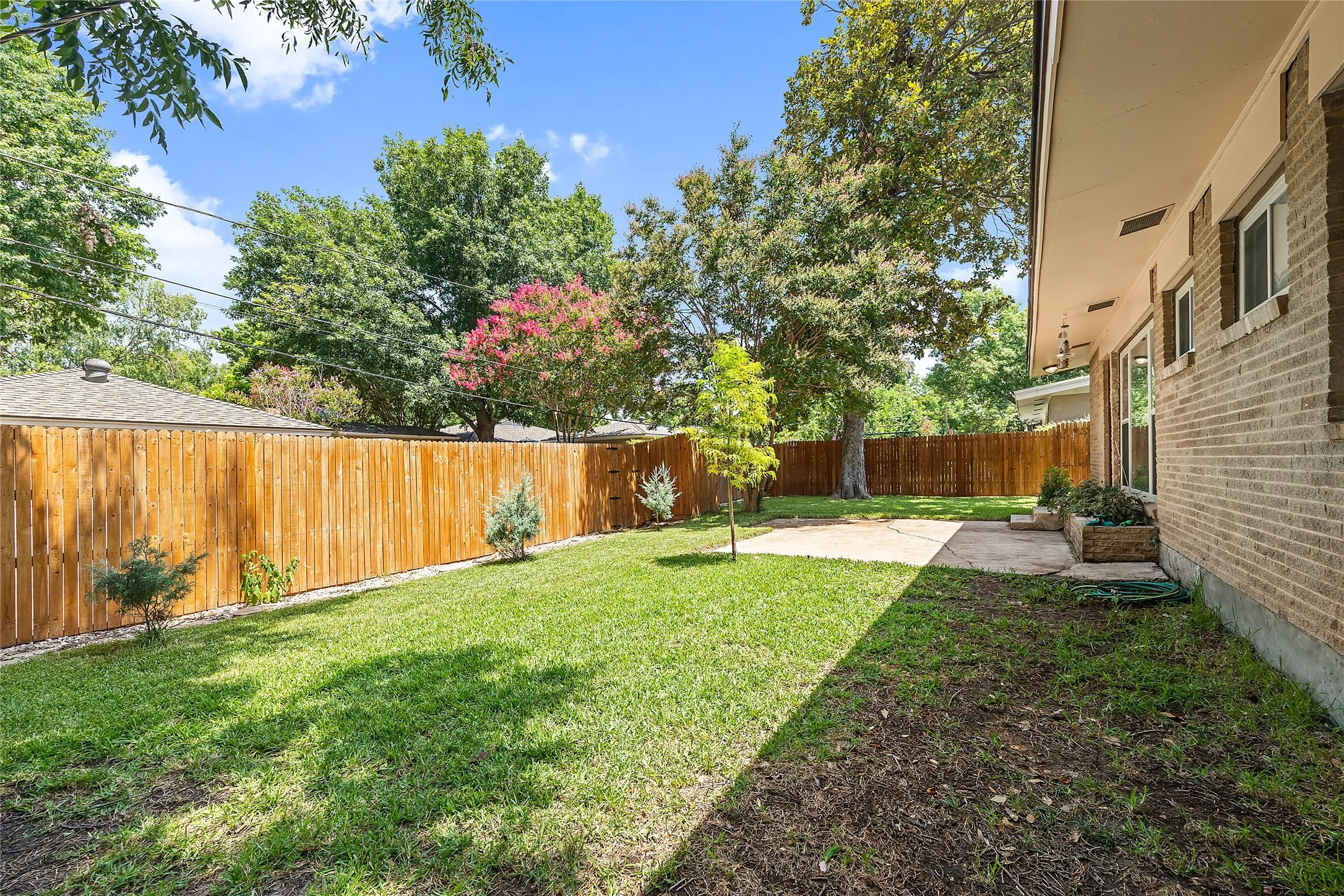 Fenced backyard with a patio area