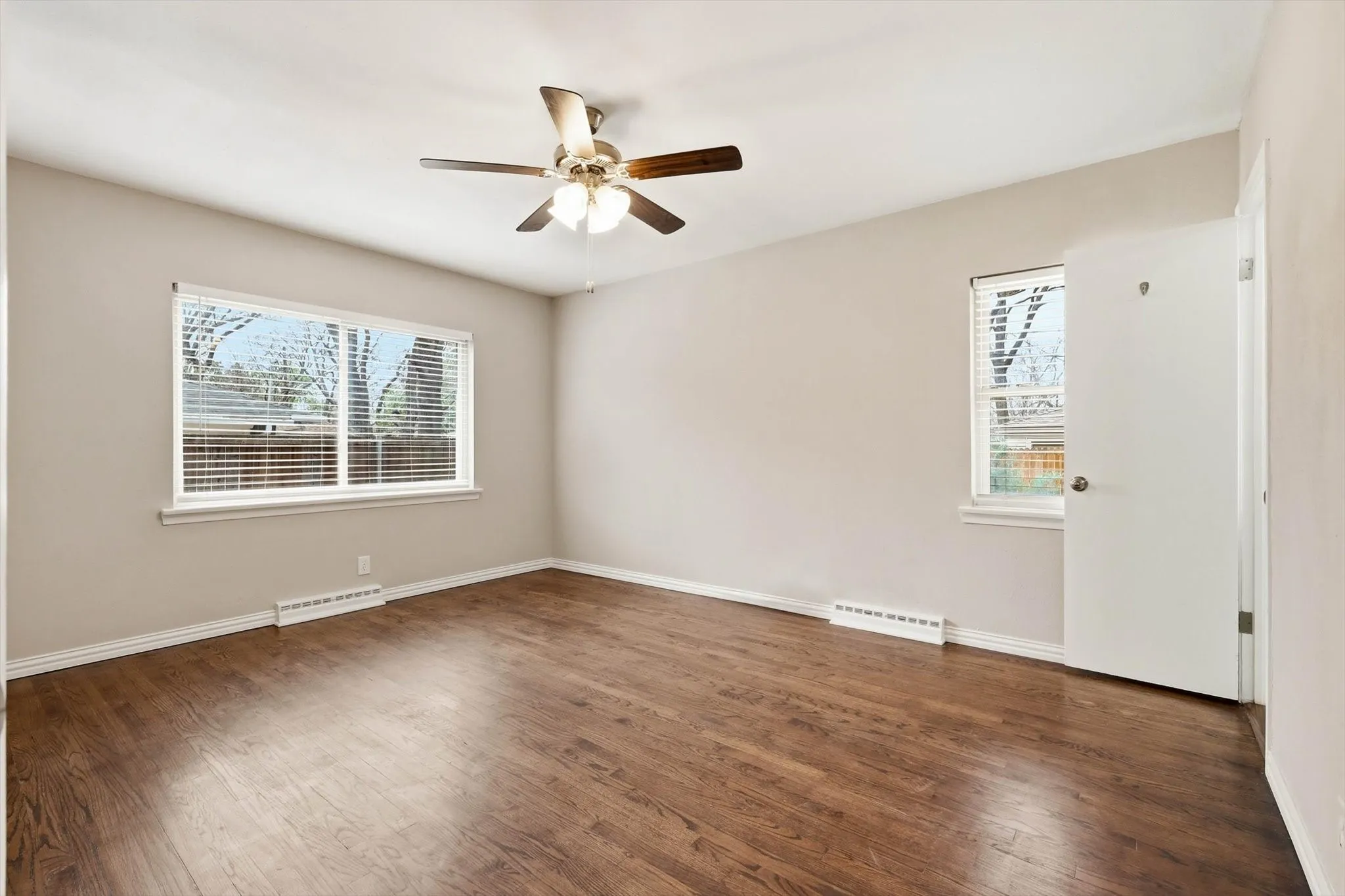 Unfurnished room with dark wood-style flooring and a ceiling fan