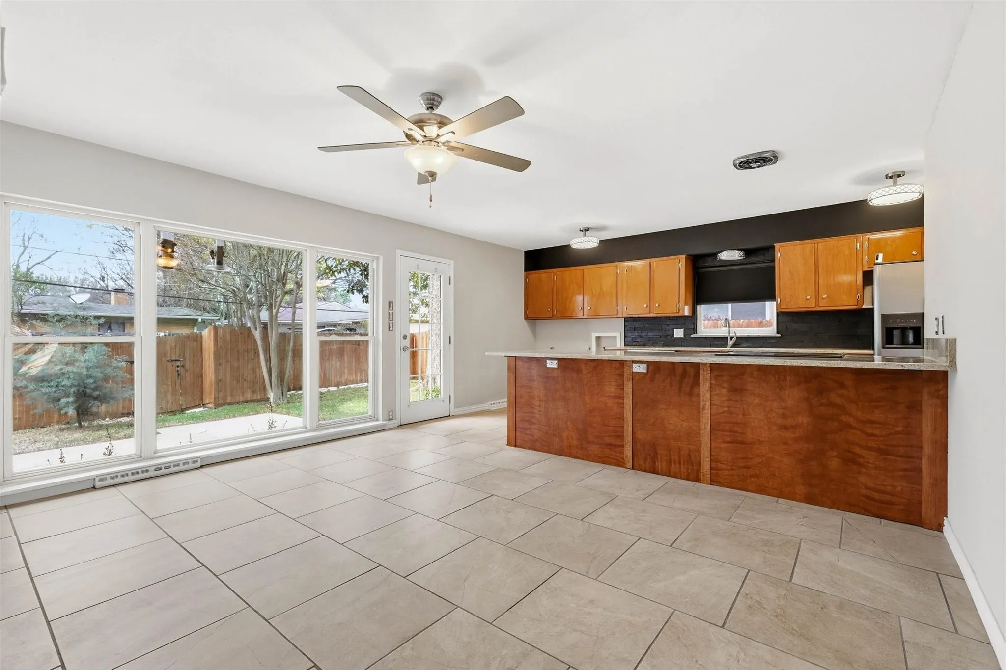 Kitchen featuring a peninsula, wood finish cabinets, light countertops, and ceiling fan