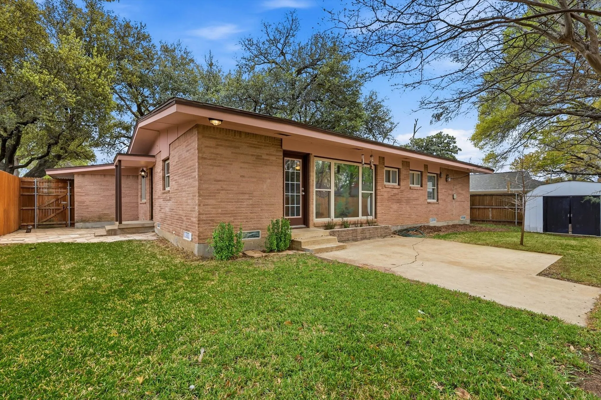 Rear view of house featuring a patio, a fenced backyard, crawl space, and brick siding