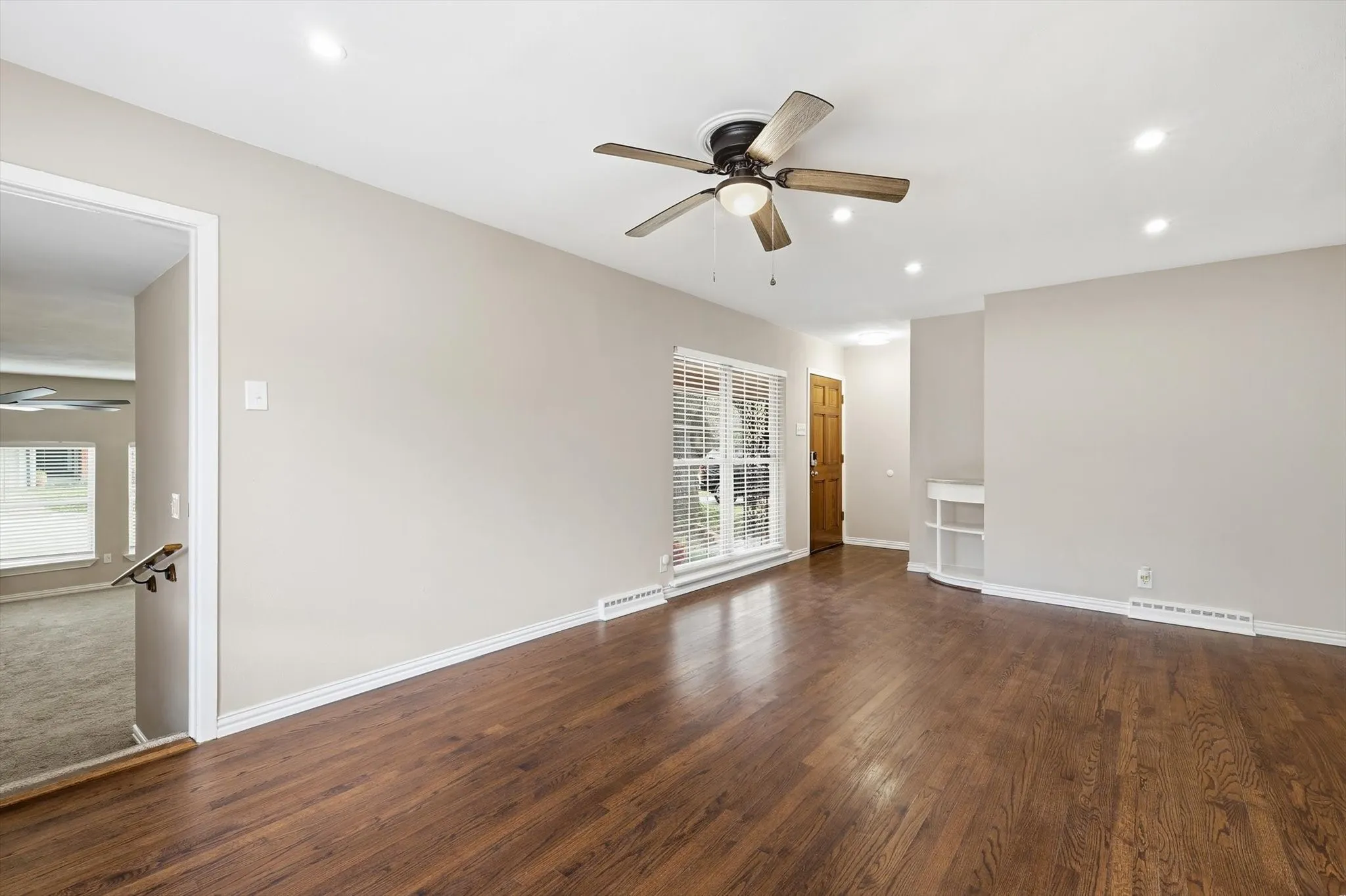 Living room with a ceiling fan, dark wood-style floors, and recessed lighting