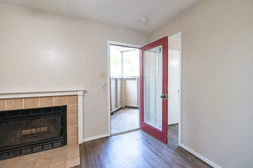 Entrance foyer featuring wood finished floors, a textured ceiling, and a tile fireplace
