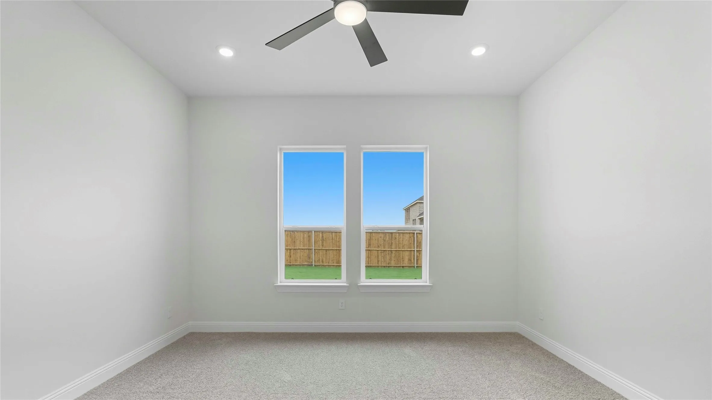 Bedroom with neutral carpeting, two large windows, a ceiling fan, and recessed lighting