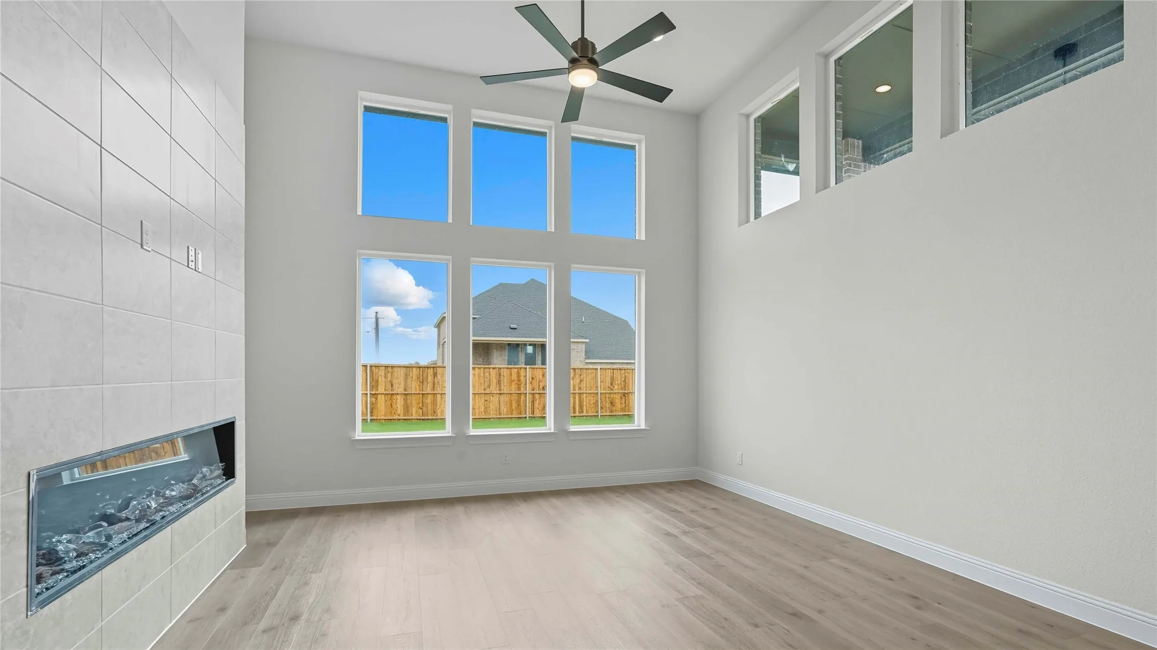 Two-story living area featuring a tiled fireplace with a linear insert